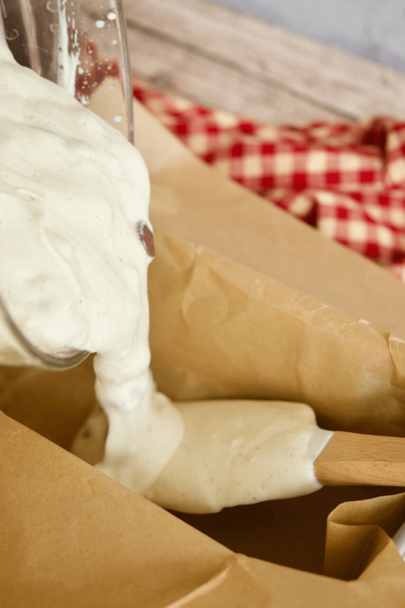 Scooping half of the Moose tracks ice cream mixture into prepared pan.