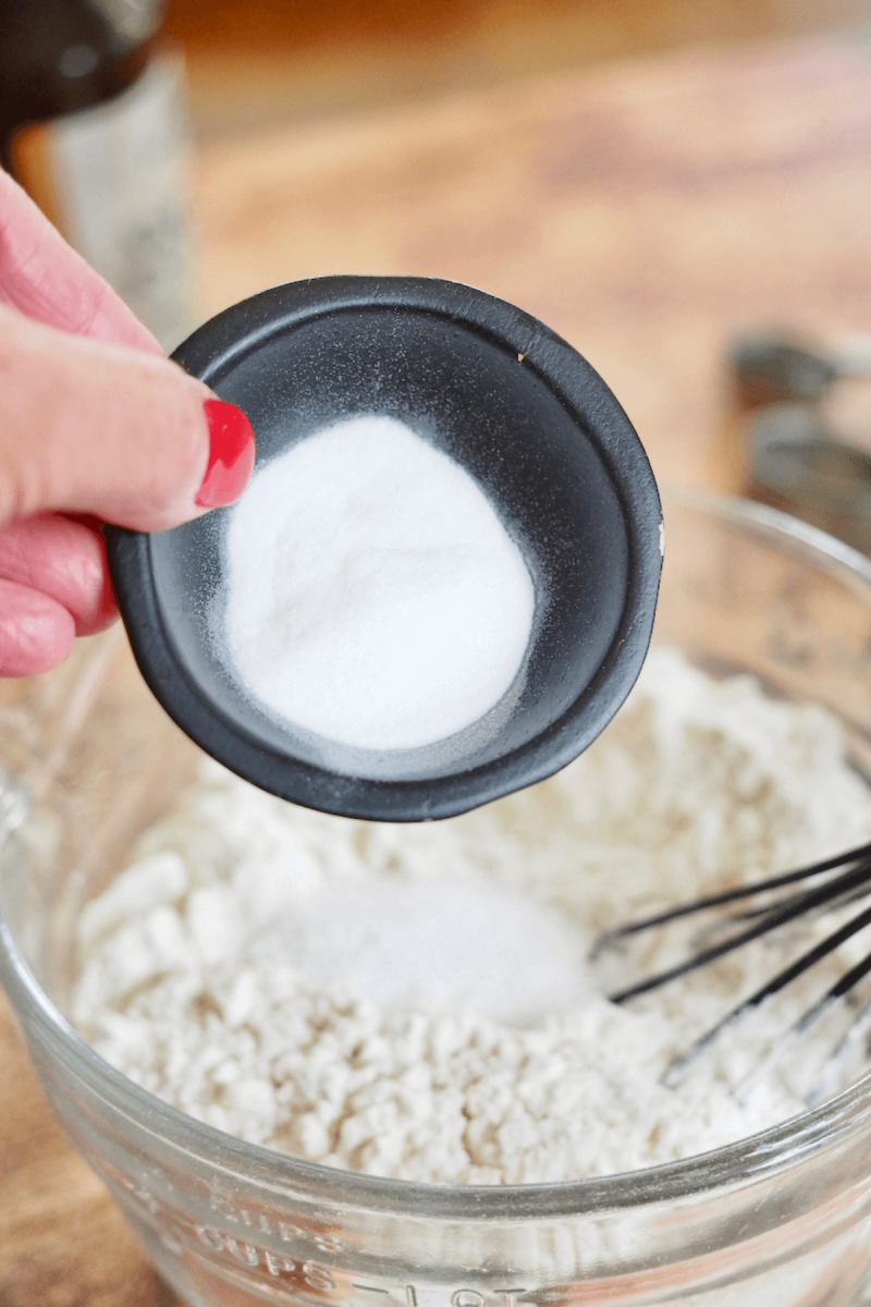 Adding salt and baking soda to dry ingredients for crumbl recipe.