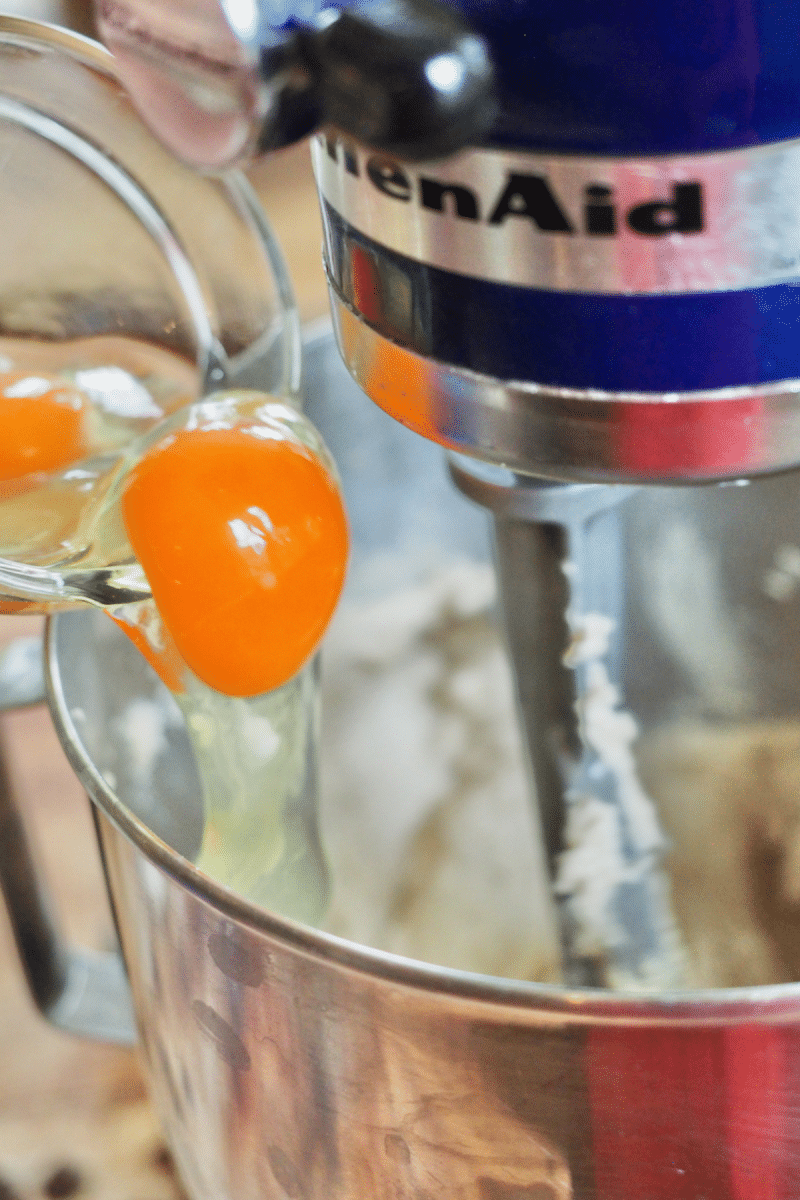 adding eggs one at a time into batter for crumbl cookies.