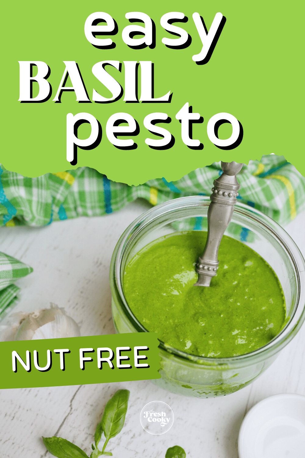 Quick and easy basil pesto without nuts pin, jar of pesto sauce on counter with bright green basil nearby, garlic and a scoop in the pesto sauce.