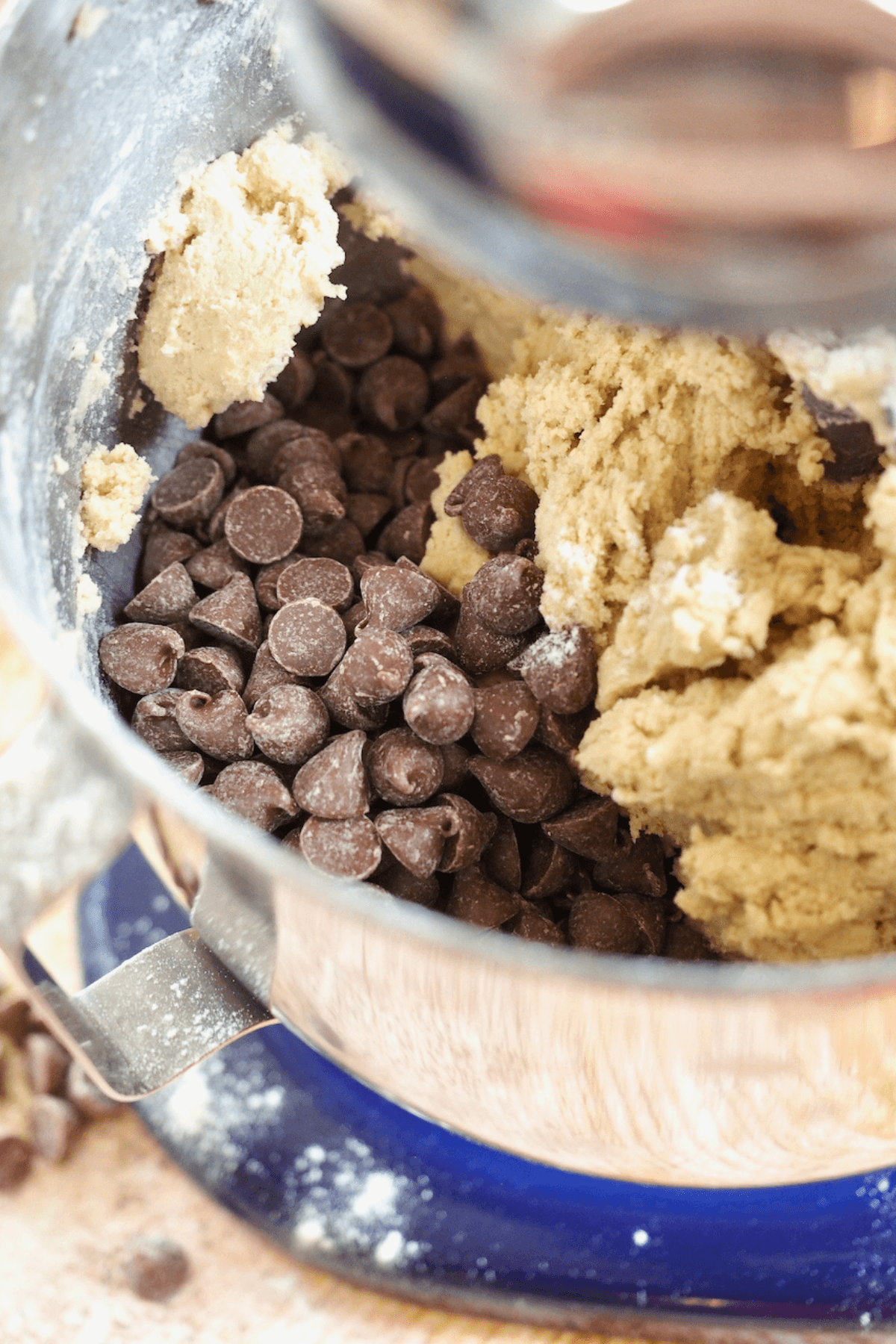 Chocolate chip cookie batter with milk chocolate chips mixing in.