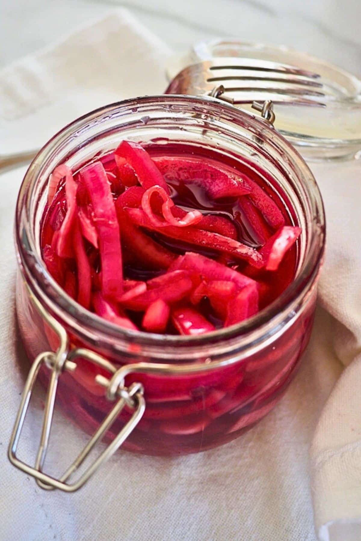 Refrigerator pickled red onions in a canning jar with a flip top.