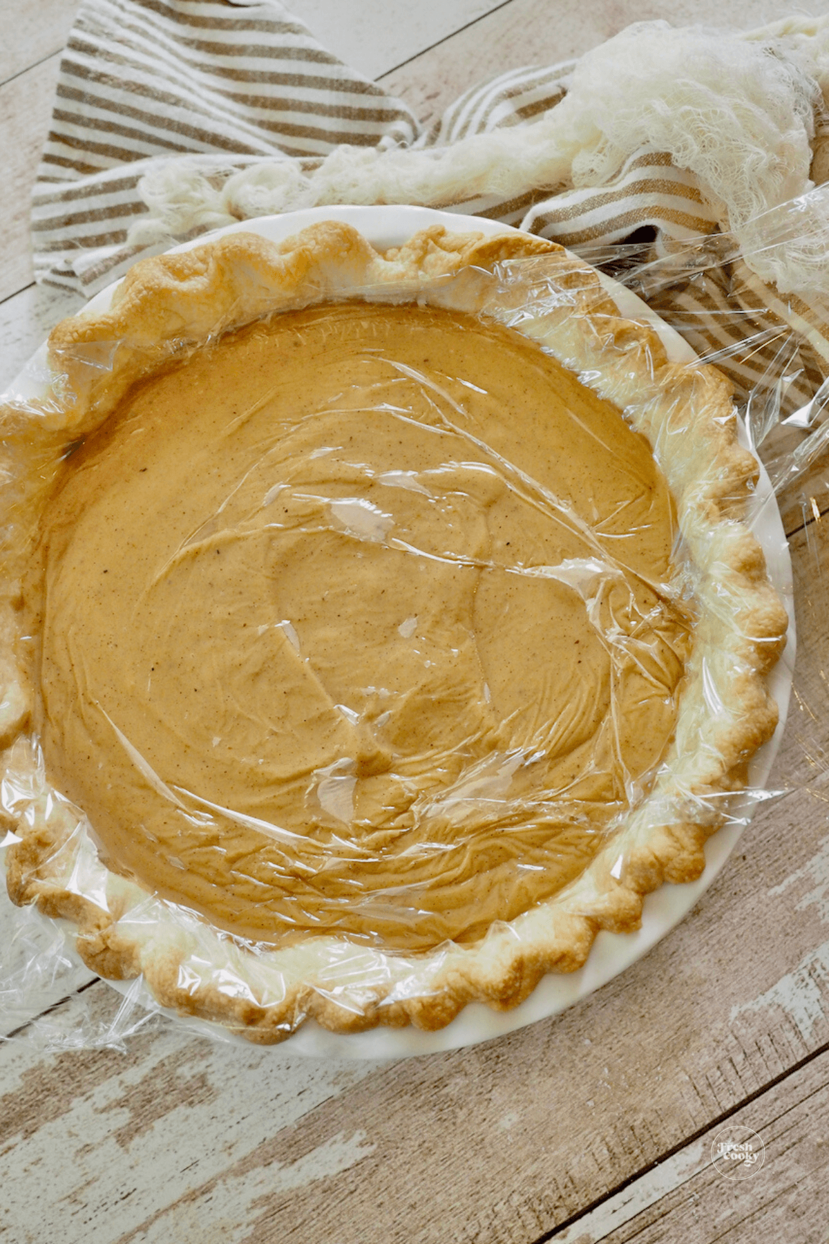 Butterscotch cinnamon pie covered with plastic wrap to cool.