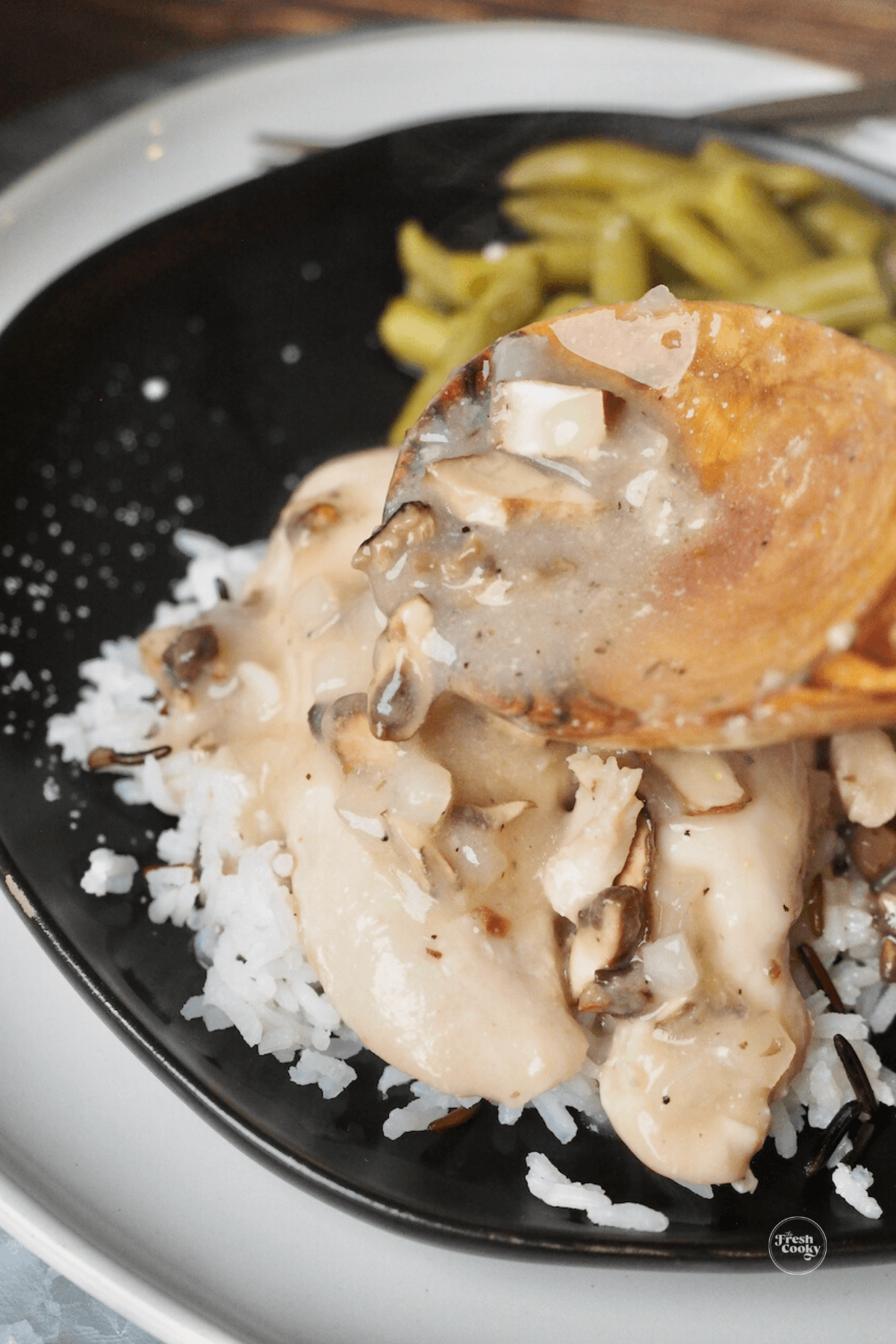 Spooning on chicken gravy over cracker barrel chicken and rice recipe.