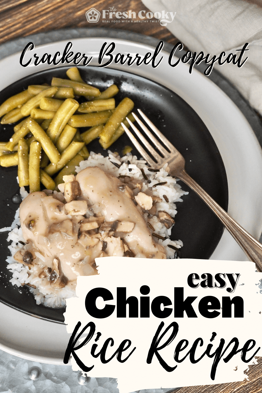 Pin for Cracker Barrel Chicken and Rice Recipe with image of creamy chicken tenderloins and chicken gravy on a bed of rice with green beans, on a pretty black plate with antique silver spoon.