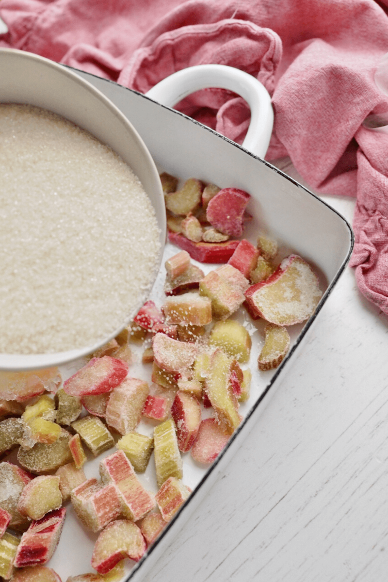 Sprinkling sugar over the top of the frozen rhubarb.