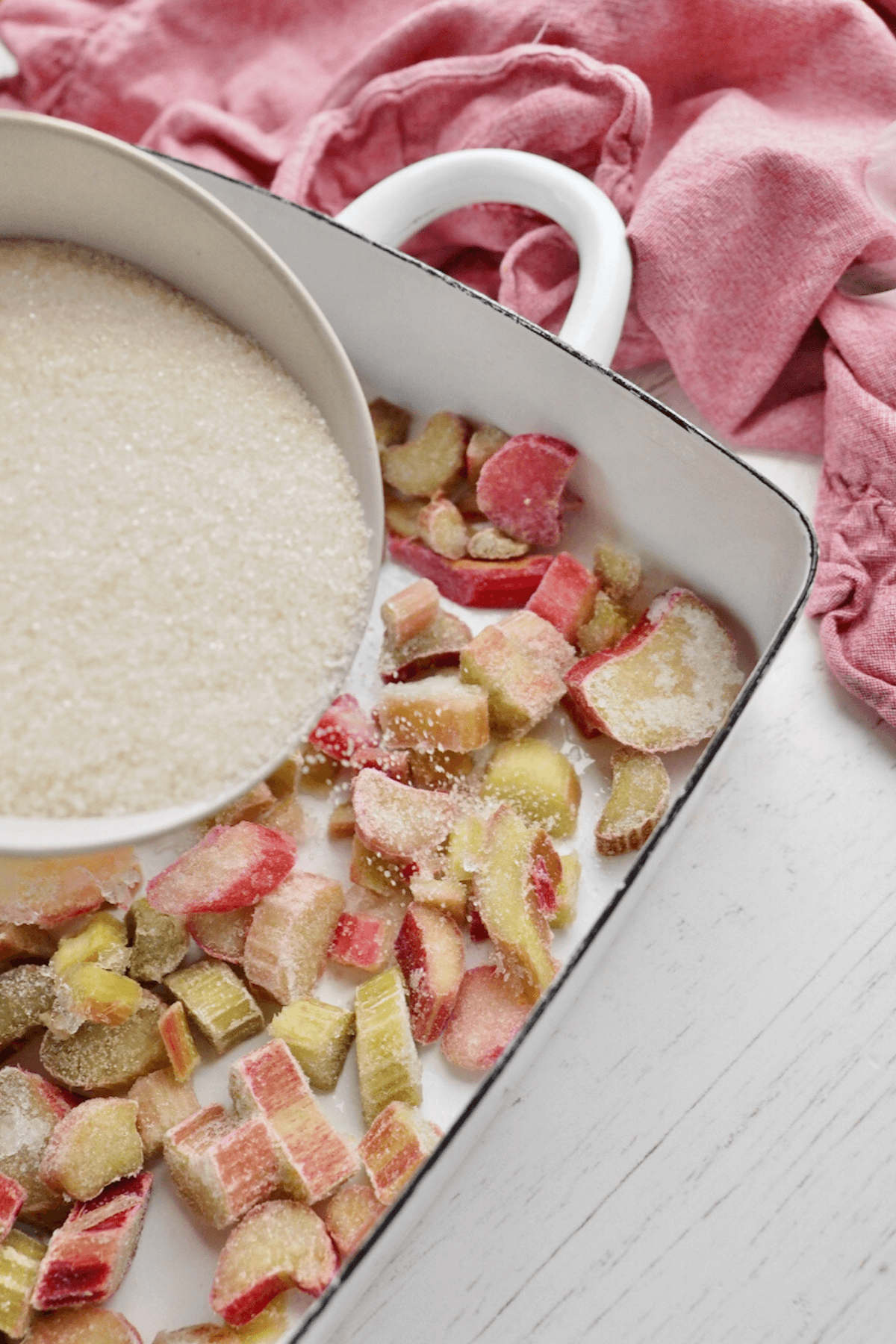 Sprinkling sugar over the top of the frozen rhubarb. 