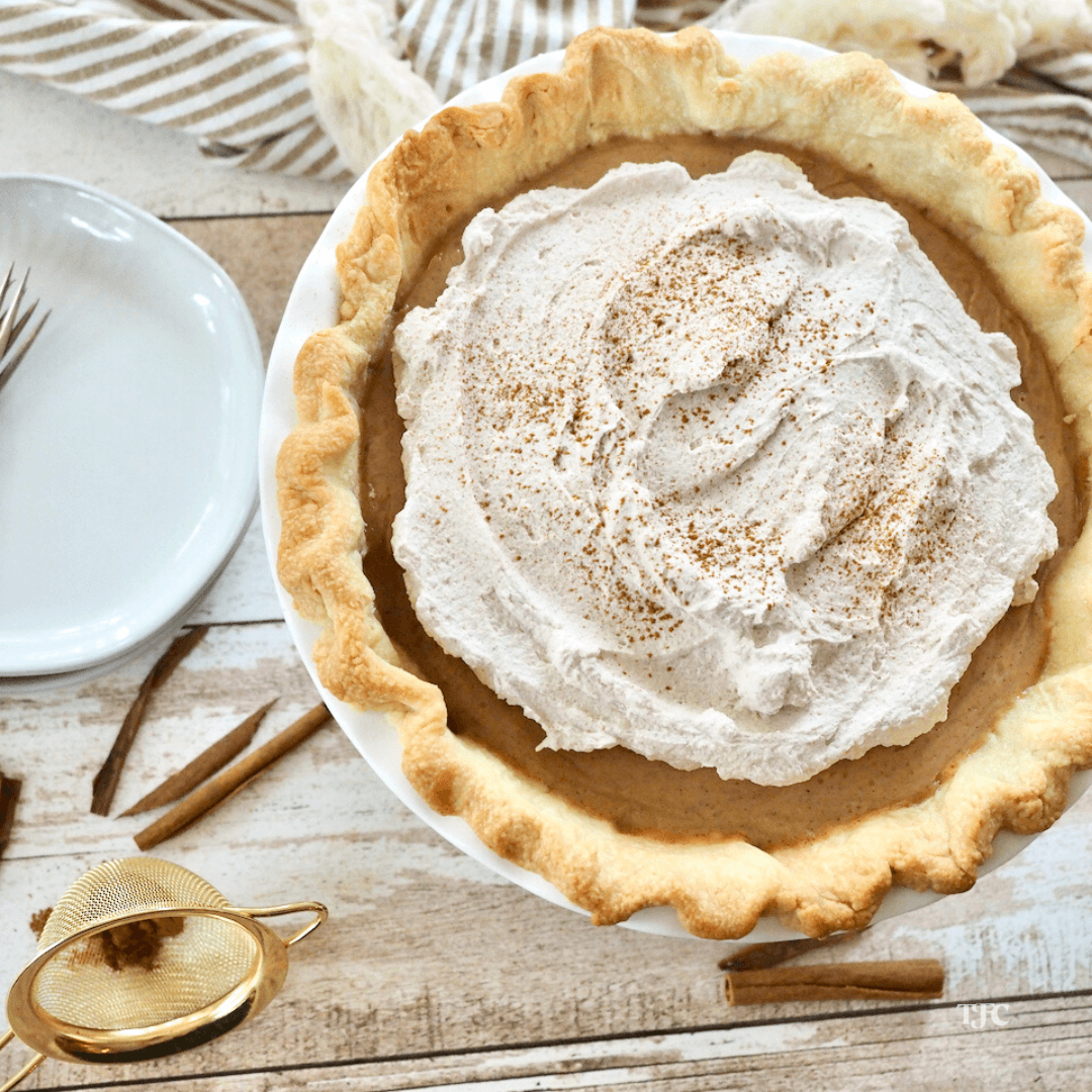 Butterscotch pie topped with cinnamon whipped cream and sprinkled with cinnamon.