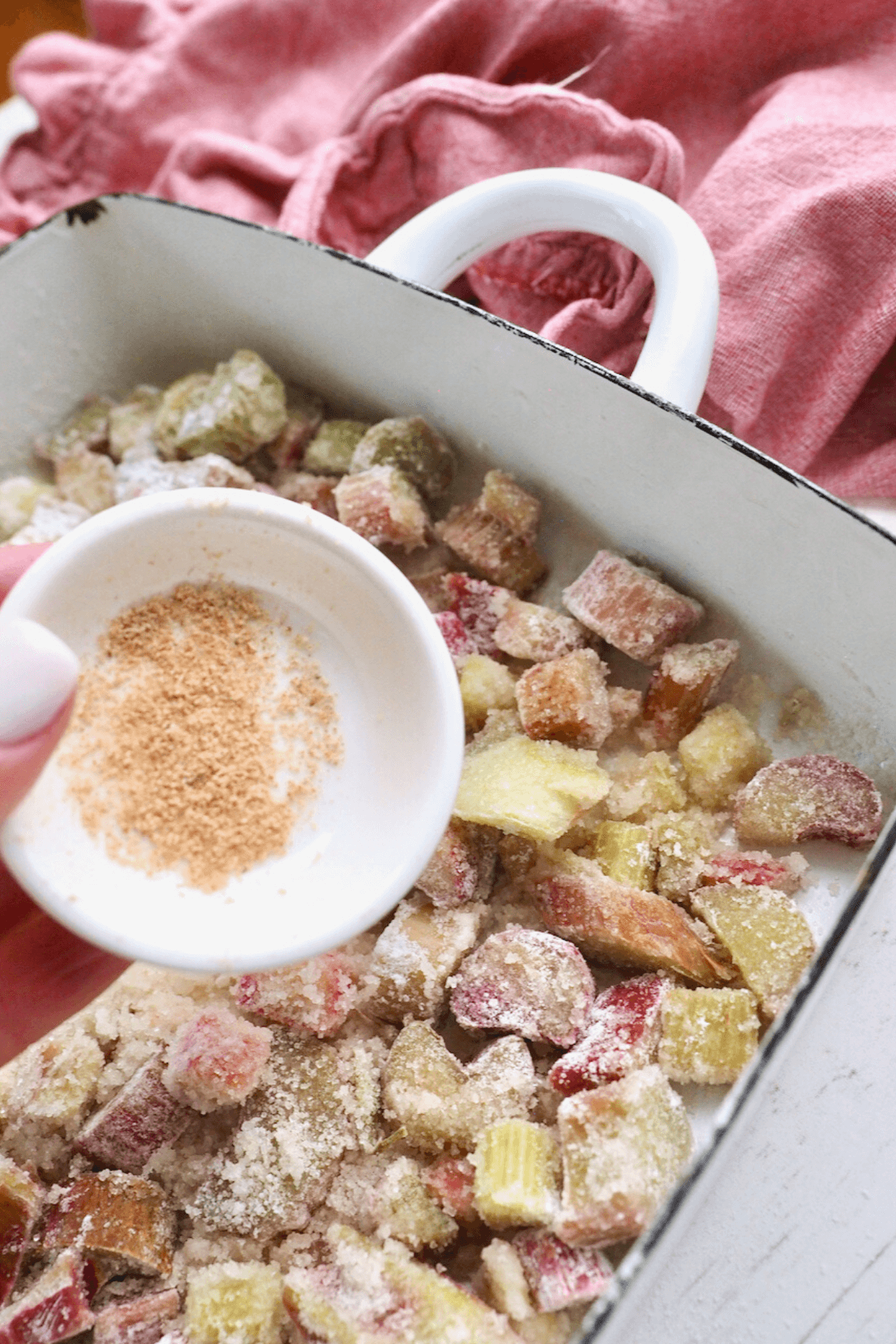 Sprinkling nutmeg over the top of the rhubarb. 