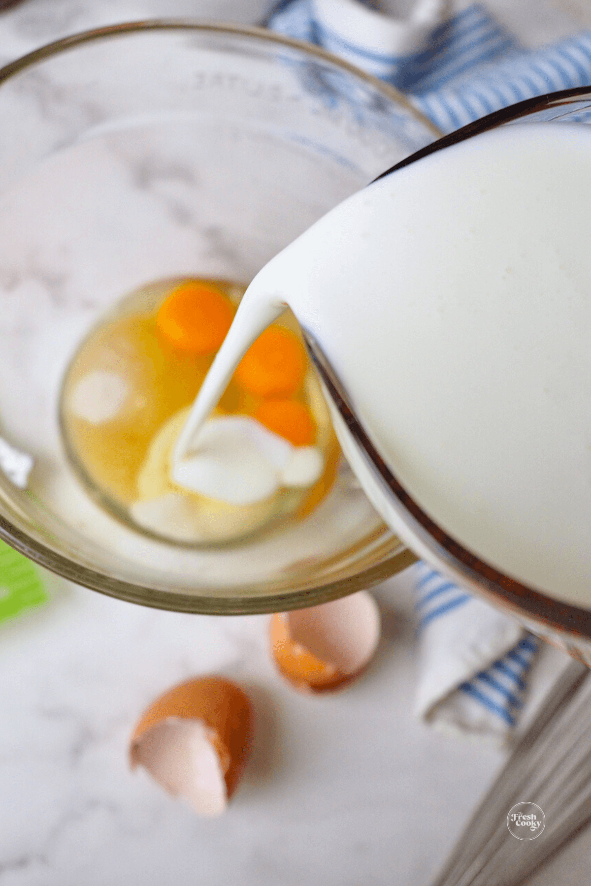 Pouring buttermilk into mixing bowl with 3 eggs for buttermilk bundt cake.