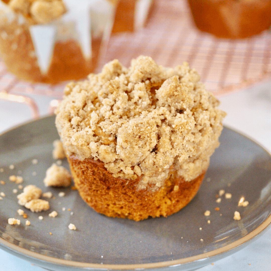 Panera Pumpkin Muffin topped with thick streusel topping on a rustic gray plate.