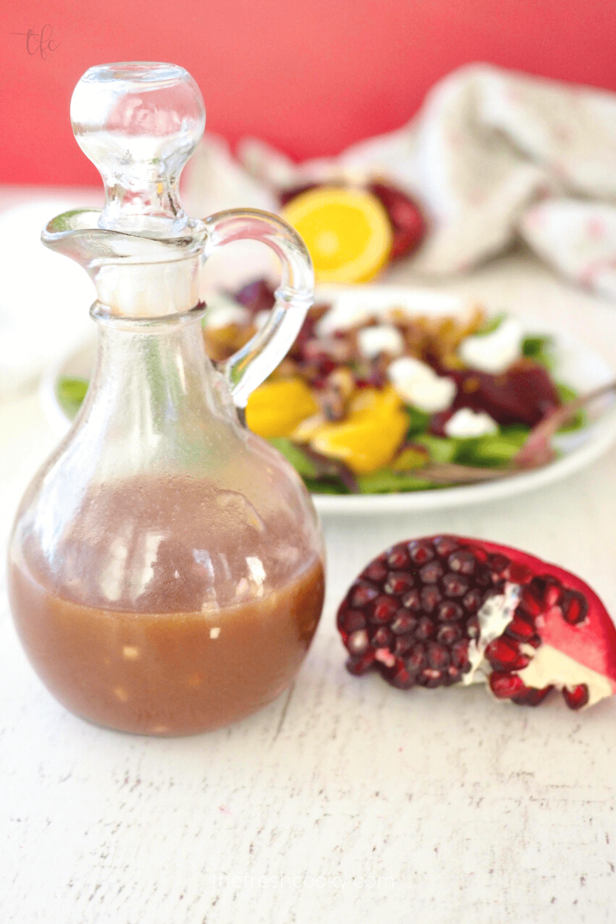 Cruet filled with pomegranate dressing for salad.