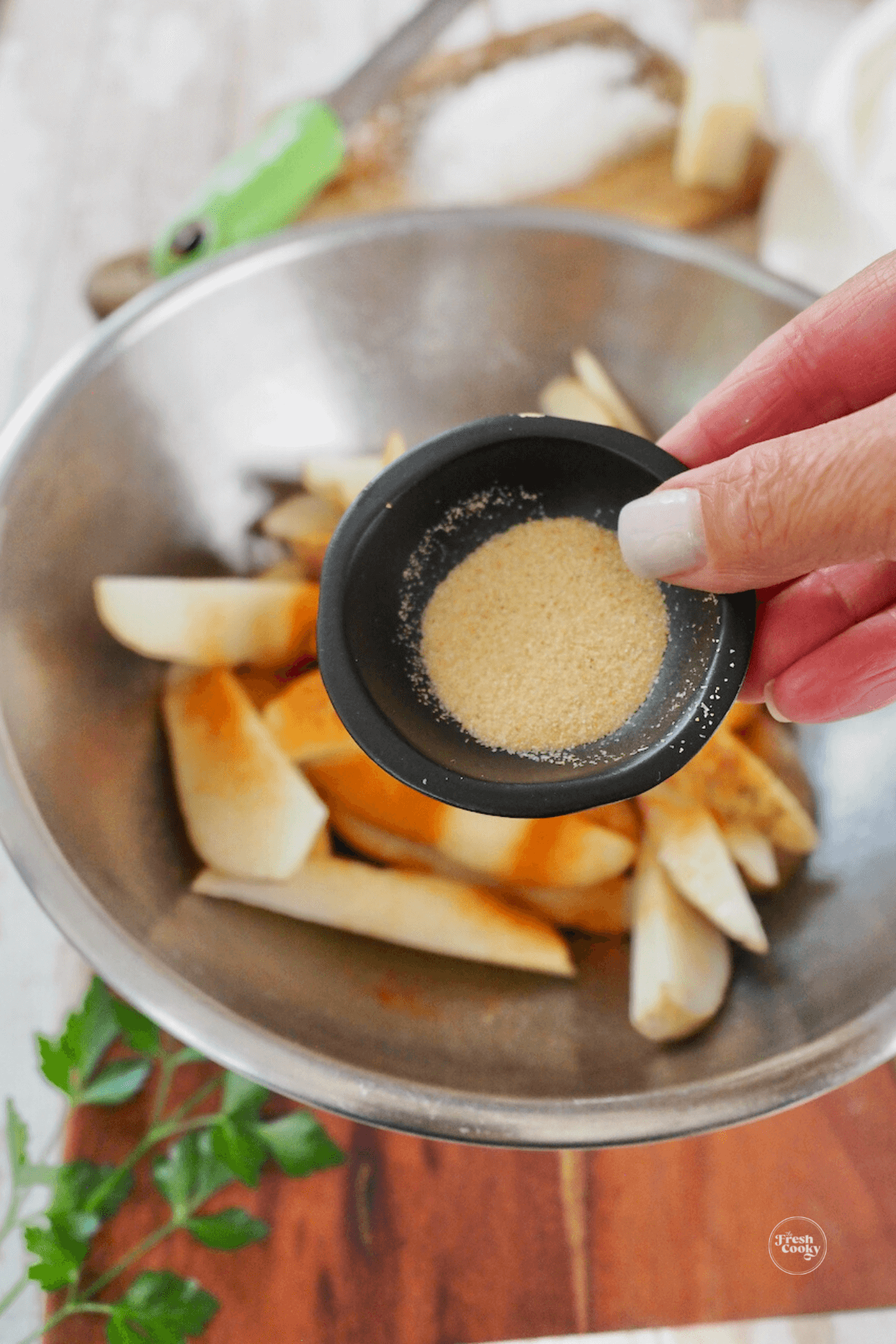 Adding garlic and onion powder to fries.