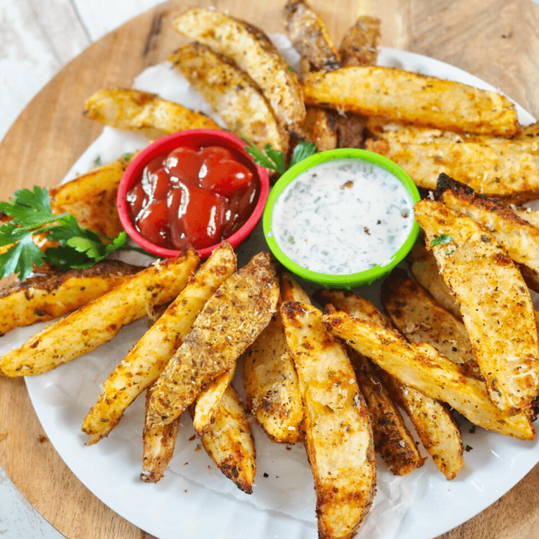 Steak fries golden brown and crispy on plate with ketchup and ranch.