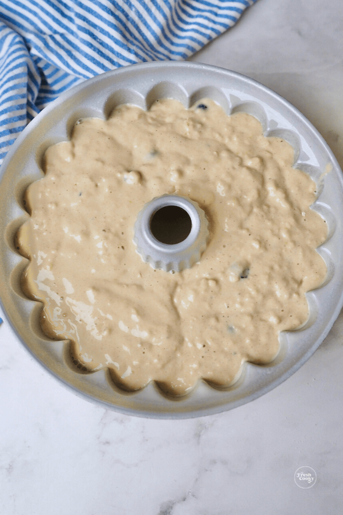 Prepared blueberry pancake bundt cake in bundt pan ready for oven.