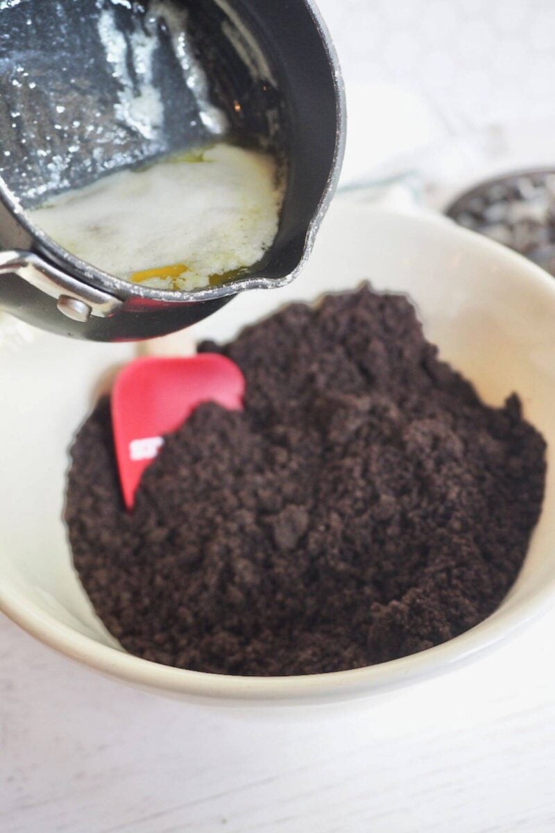 Adding butter to Oreo cookie crumbs.