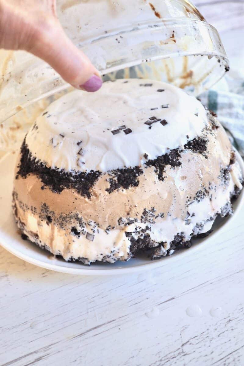 Removing ice cream cake from mold bowl.