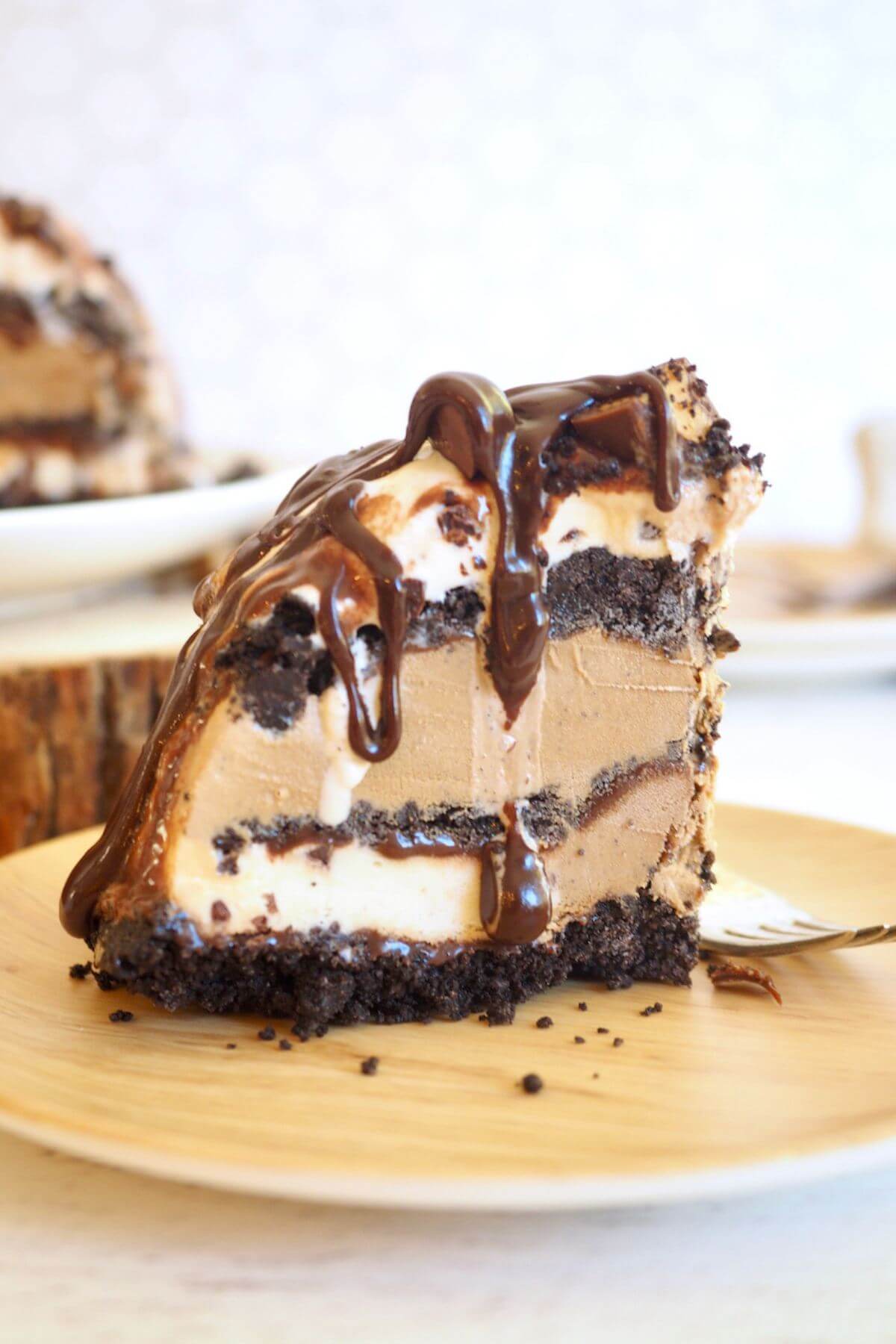 Slice of mud pie drizzled with fudge on plate.