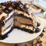 Layered mud pie ice cream cake, with a few pieces removed to show the decadent layers.