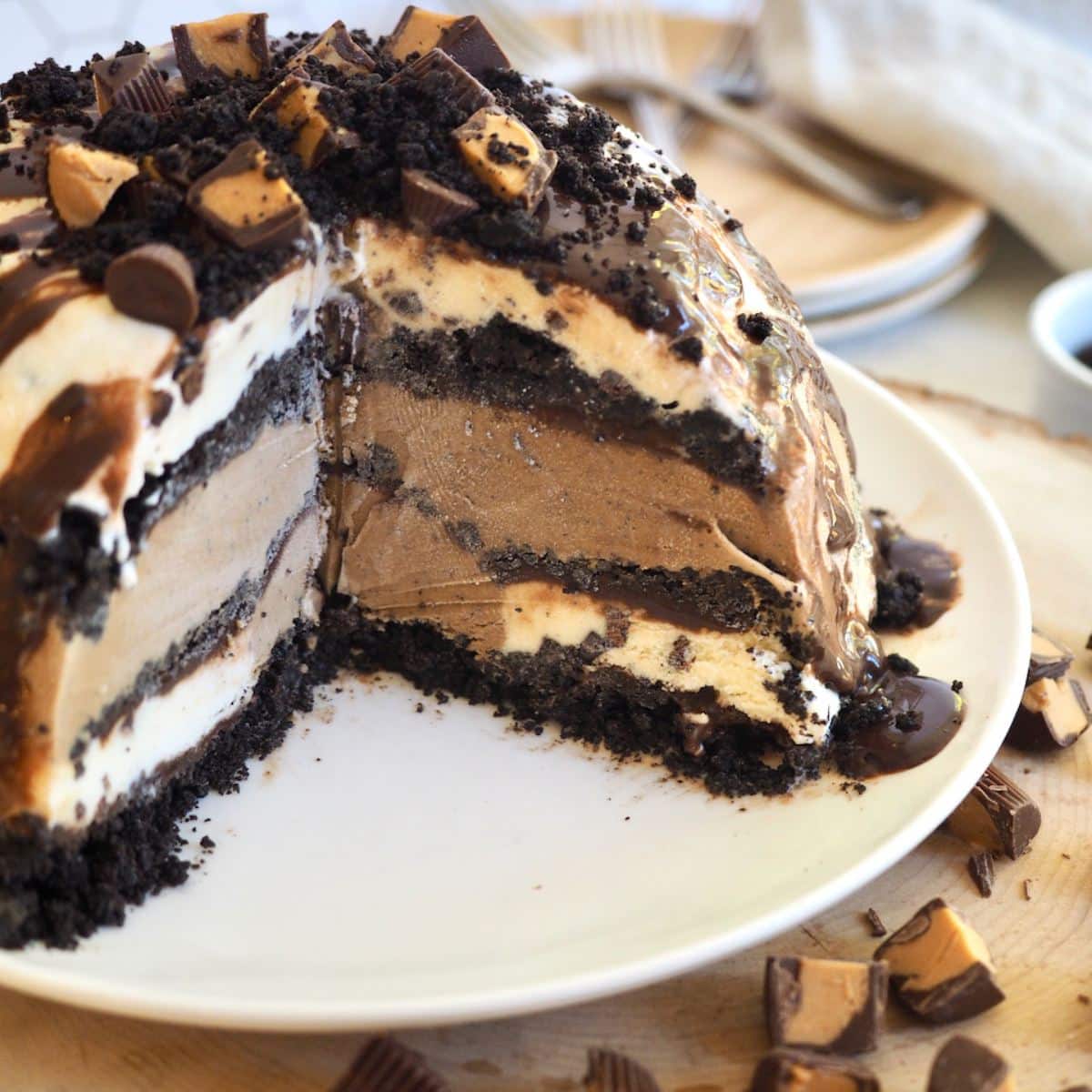 Layered mud pie ice cream cake, with a few pieces removed to show the decadent layers. 