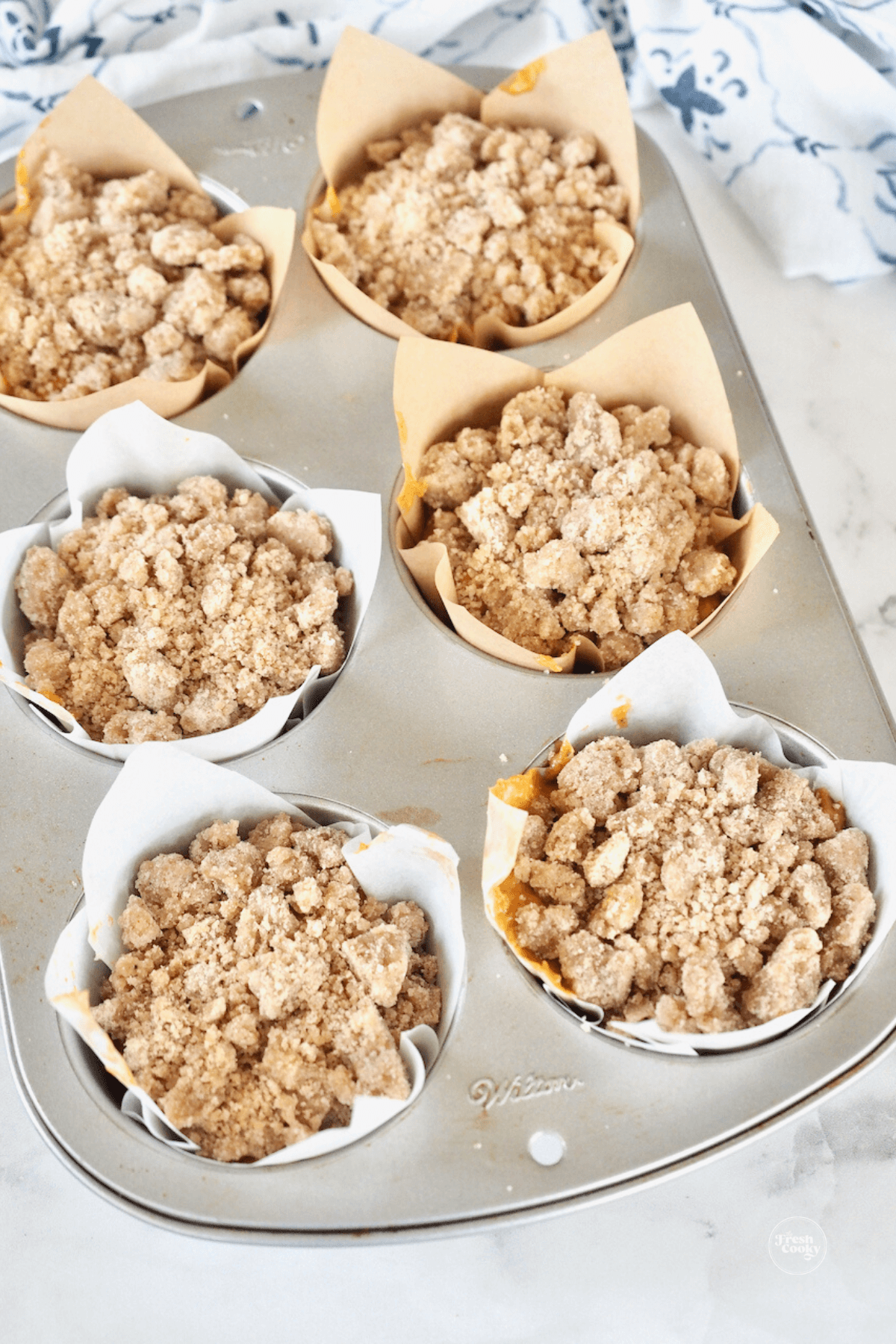 Jumbo pumpkin muffins topped with crumb topping.