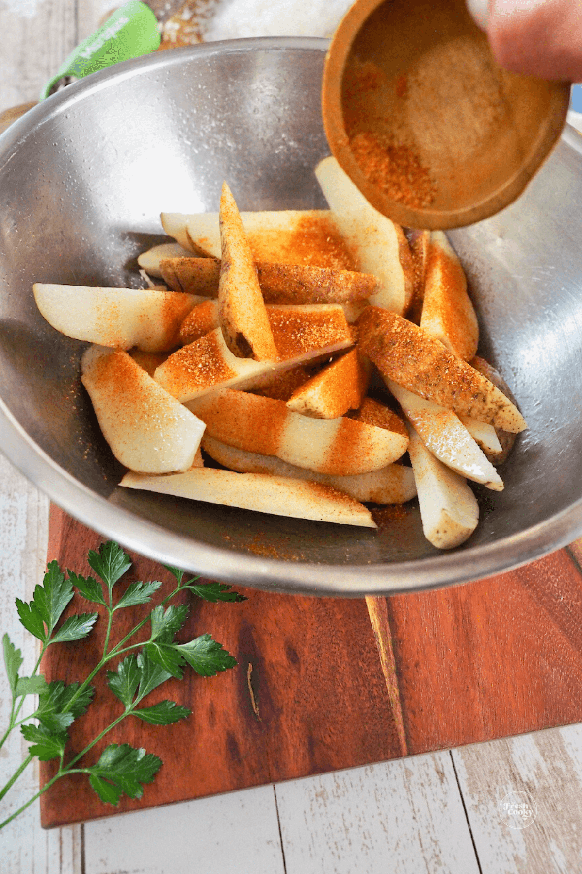 Sprinkling fries with seasoning salt.