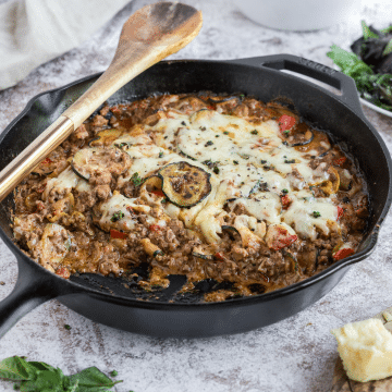 Ground Beef and Zucchini casserole in skillet with portion removed.