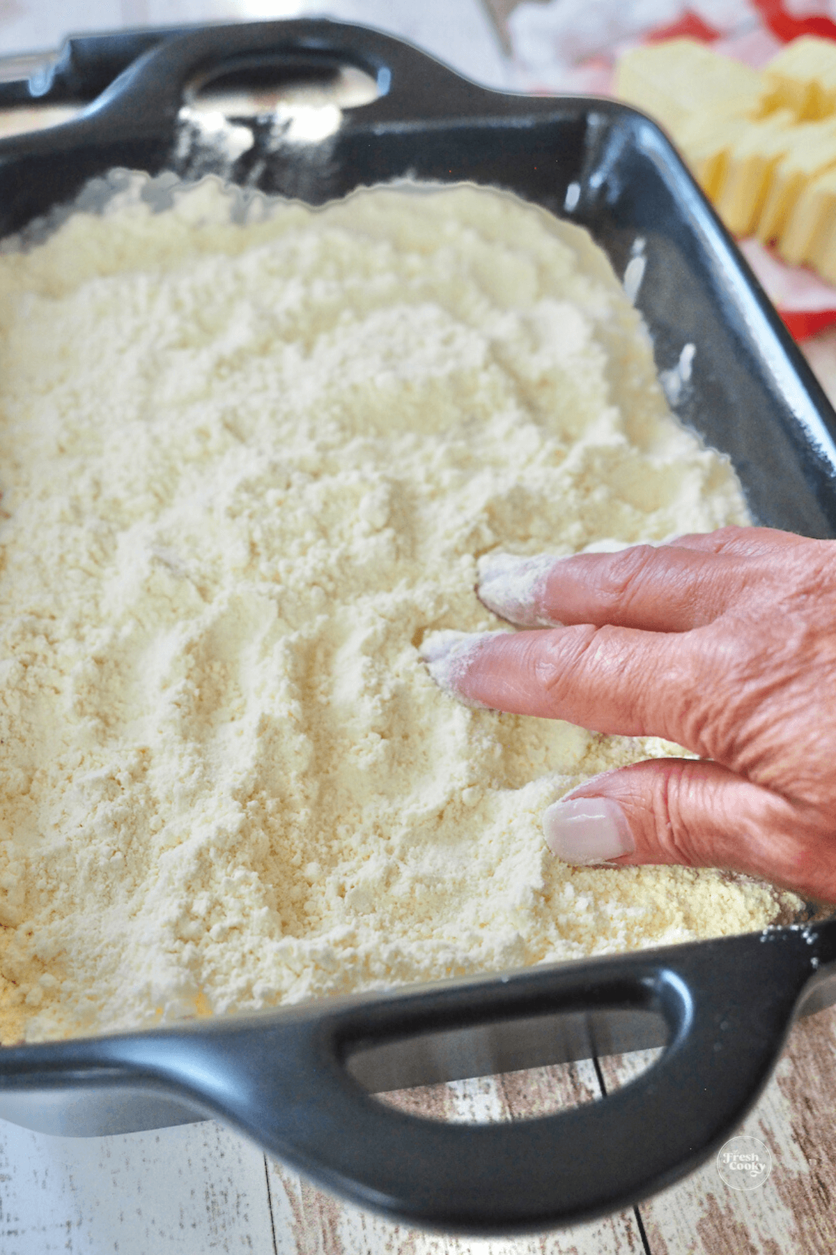 Adding cake mix to top of peach mixture. 