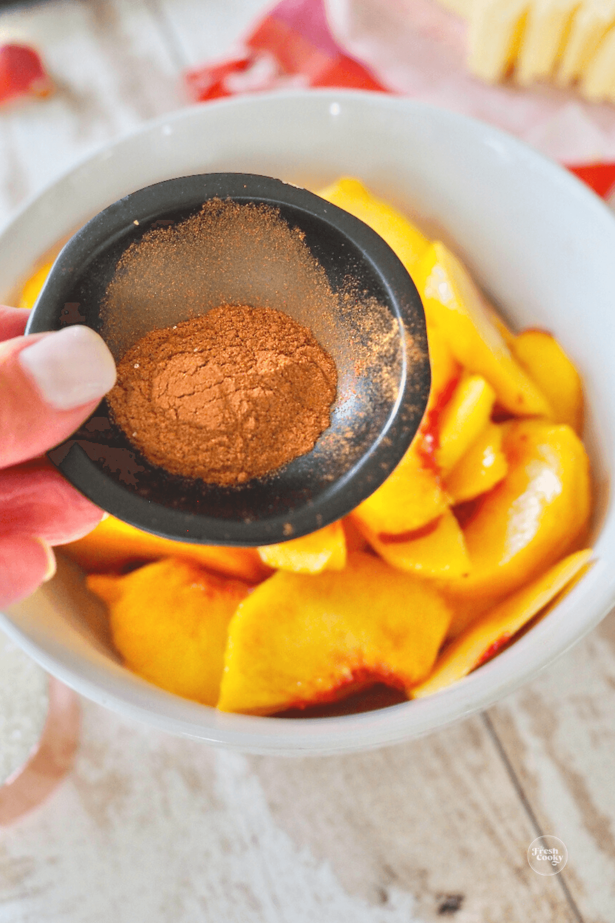 Adding cinnamon to peaches.