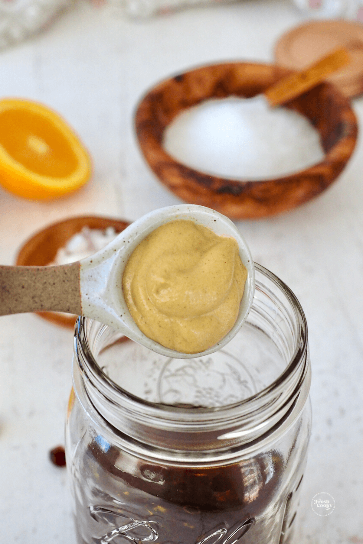 Adding dijon mustard to jar. 