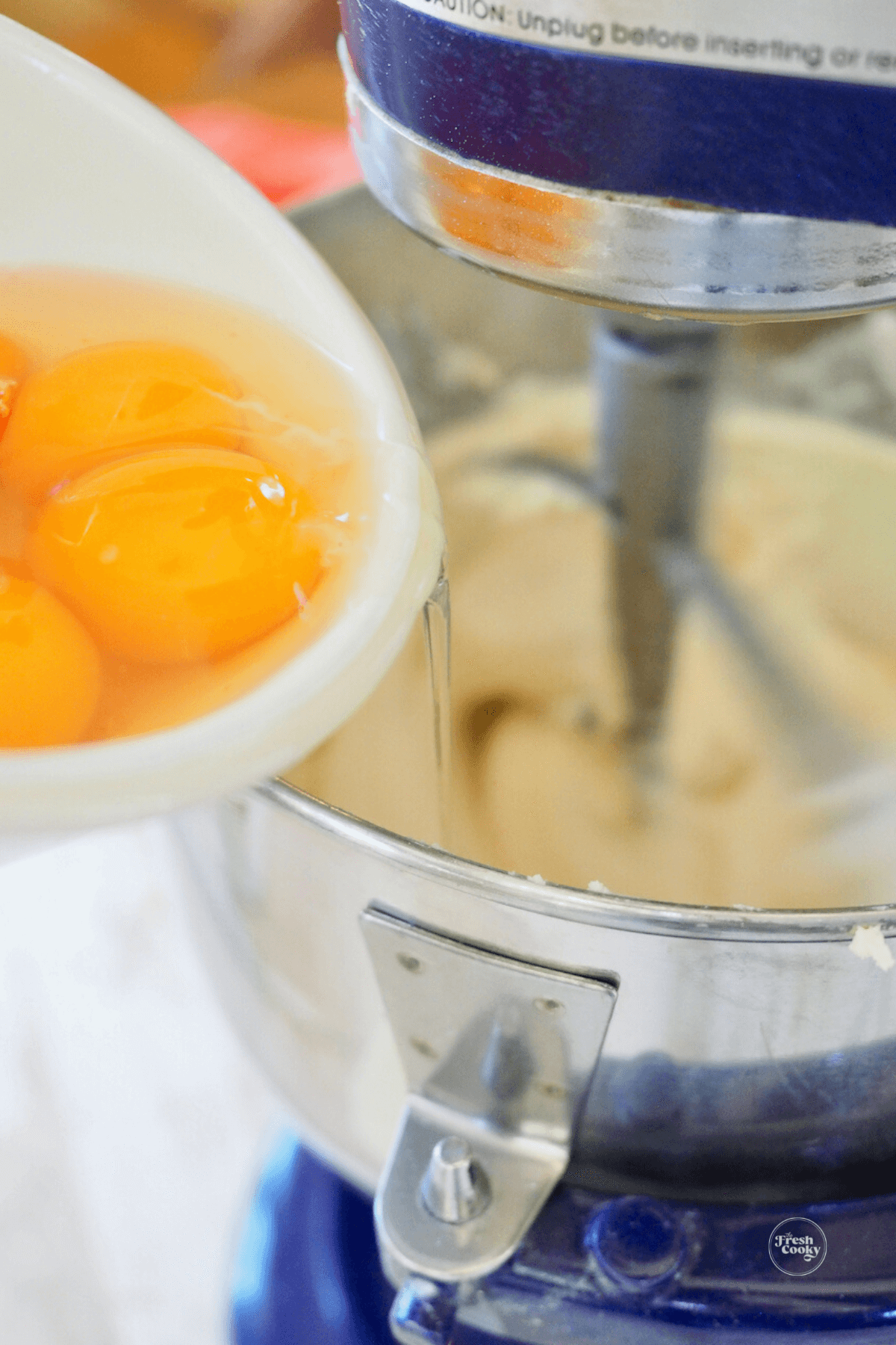 Adding eggs to batter.