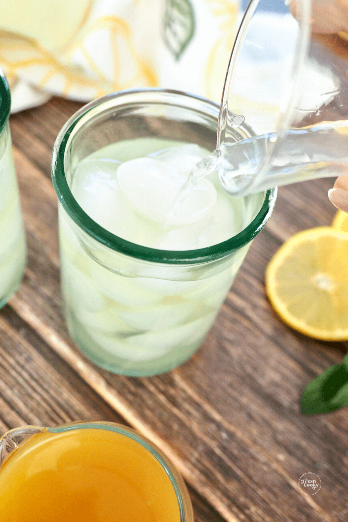 Pouring lemonade into the green tea over ice. 