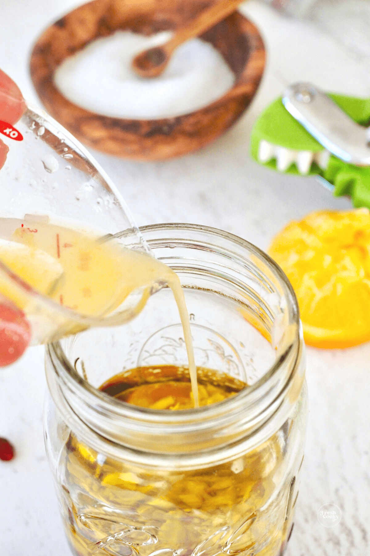 Adding olive oil to mason jar.