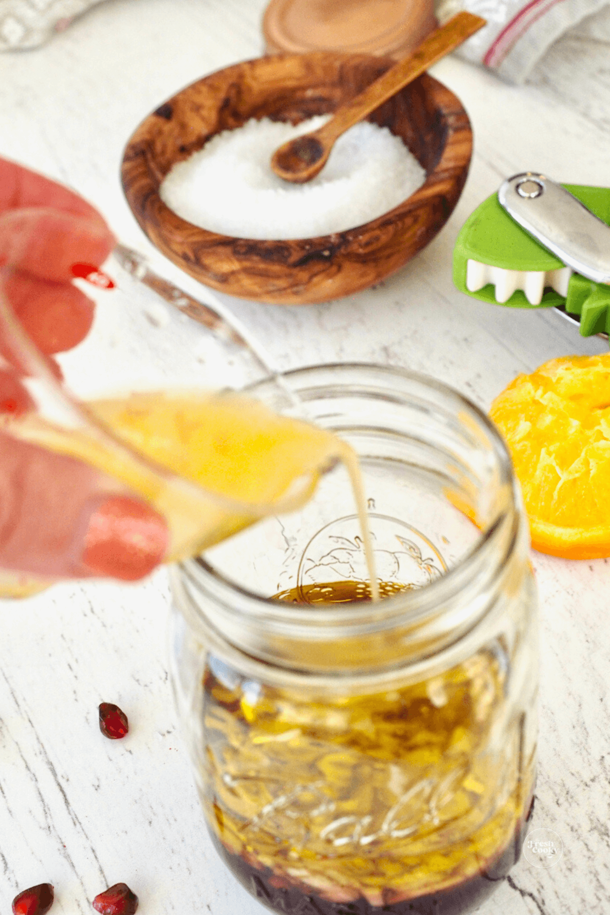 Adding orange juice to jar. 