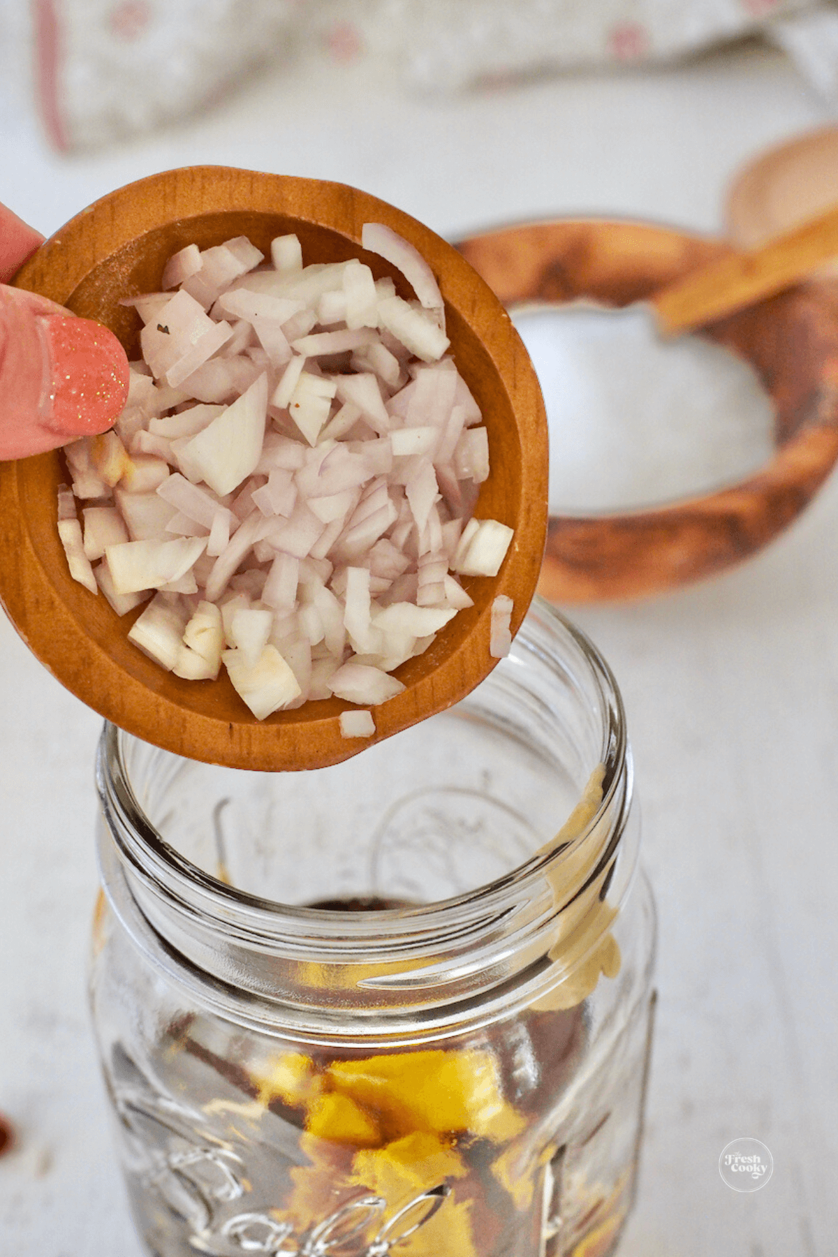 Pouring shallots into jar. 