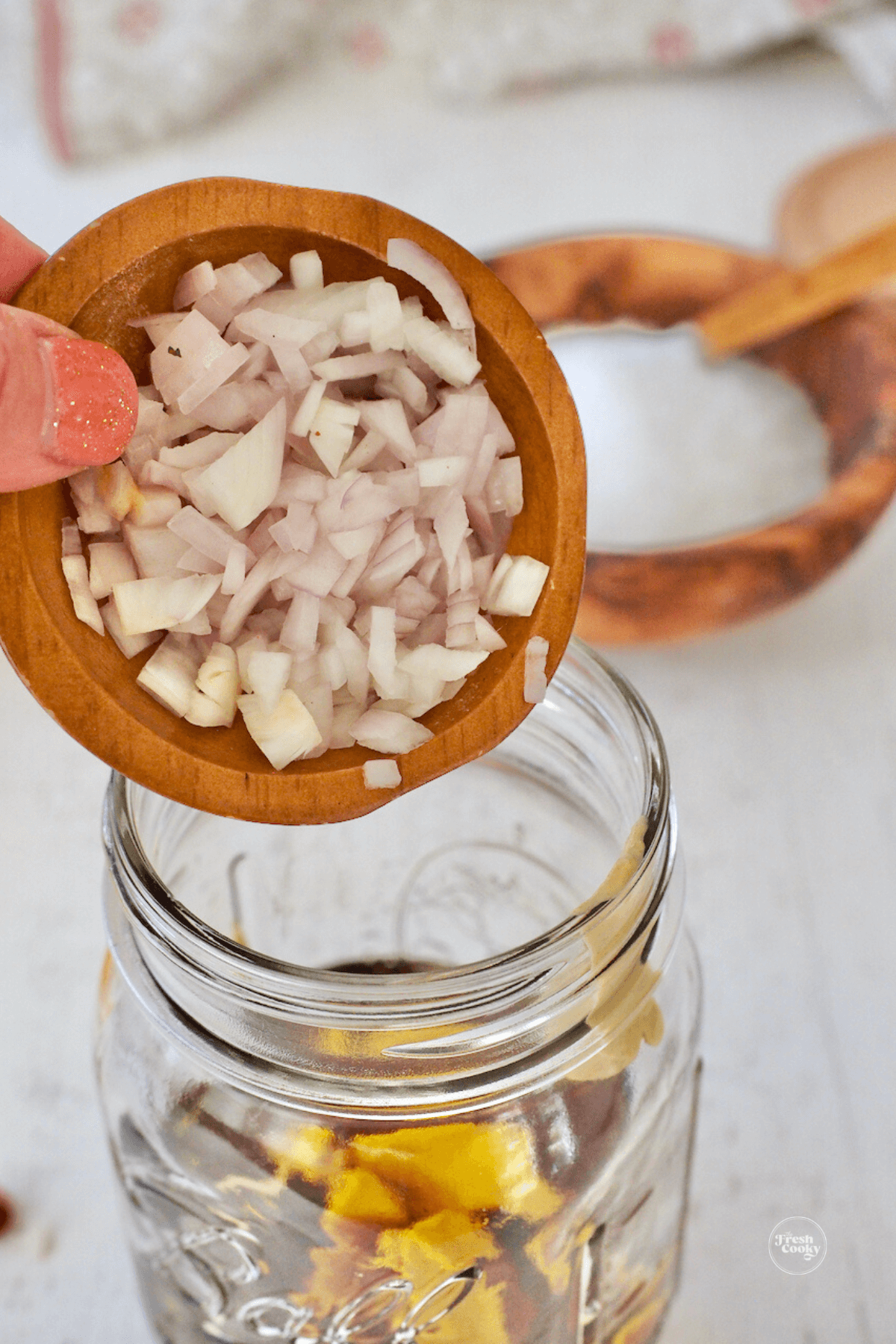 Pouring shallots into jar.