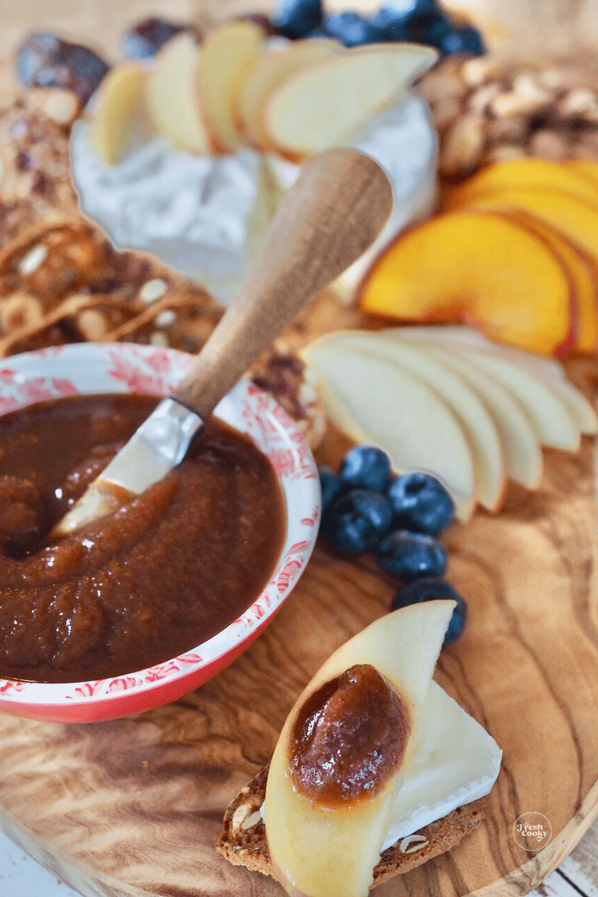 Bowl of apple butter with crackers and cheese board.