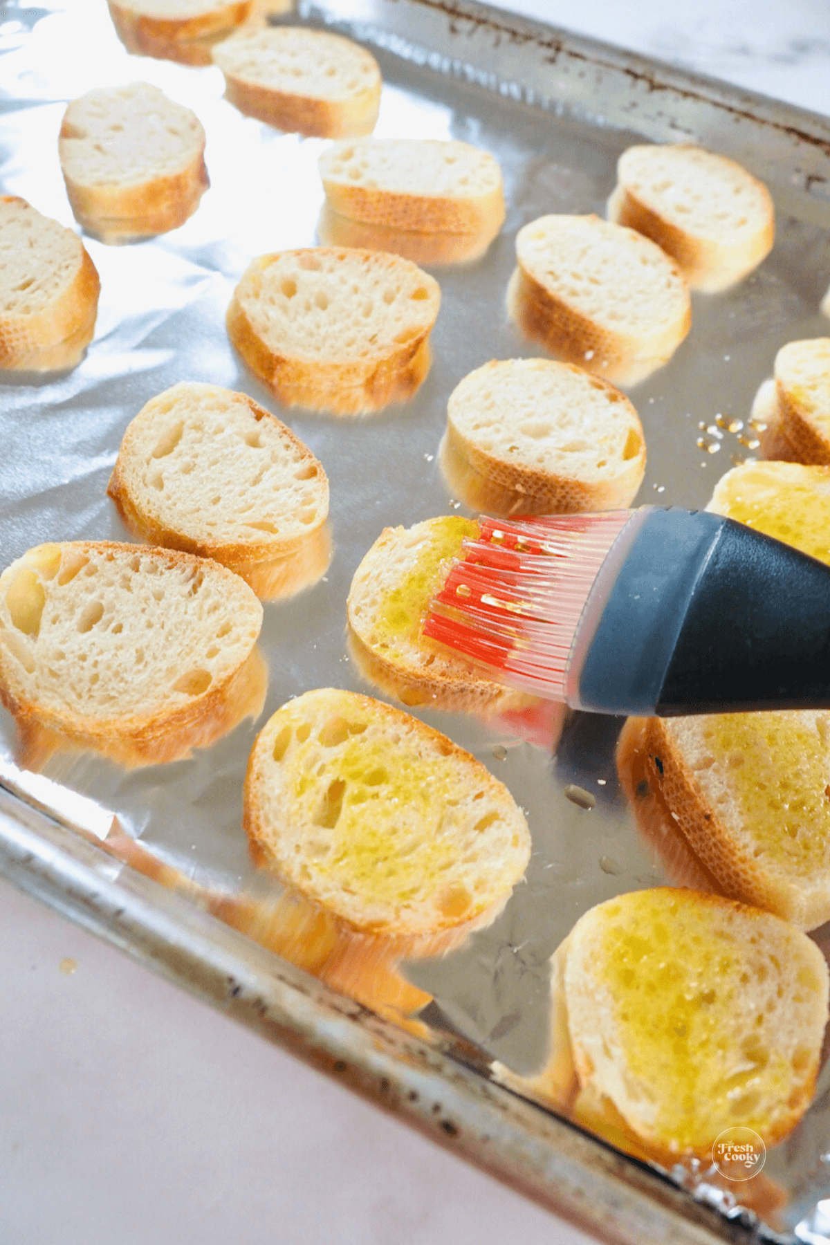 Brush baguette slices with olive oil.