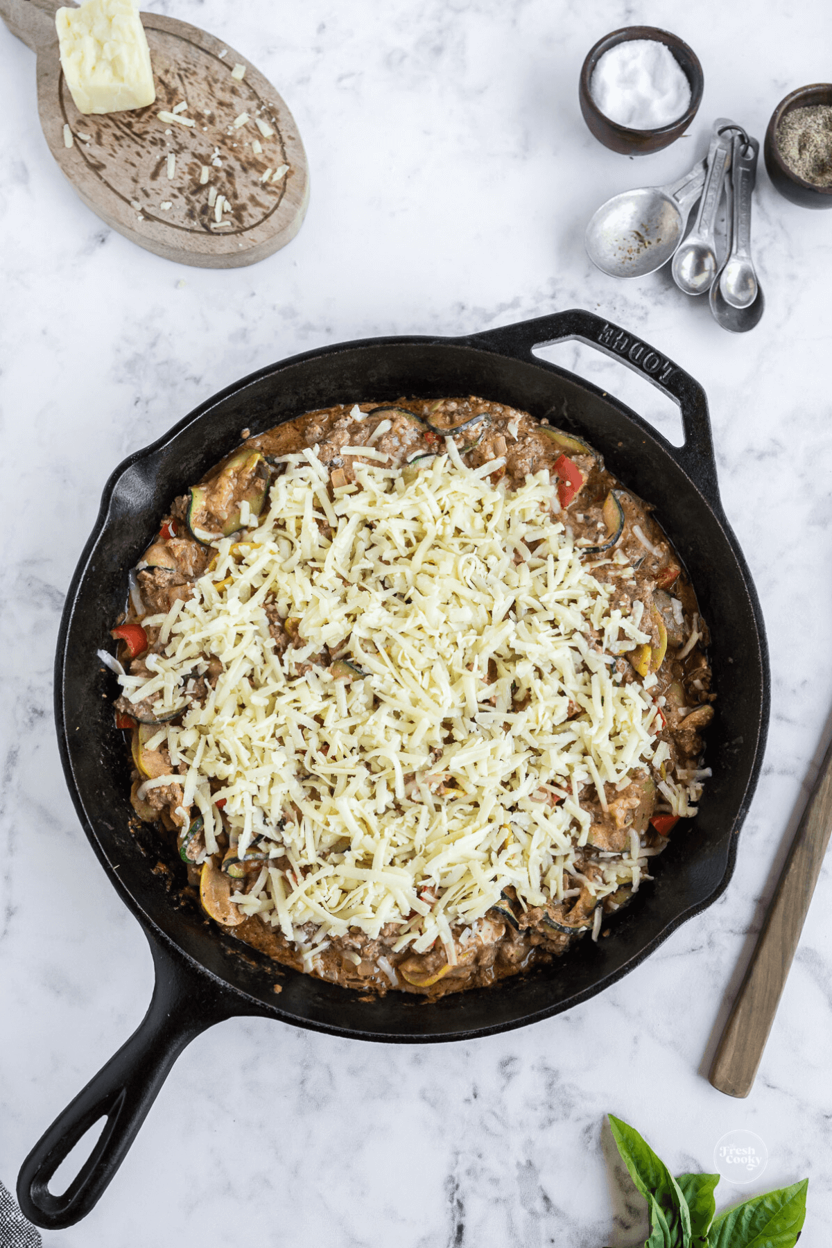 Topped with shredded cheese and ready for oven.