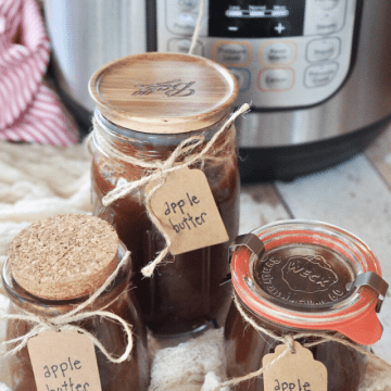 Apple butter in jars with labels and instant pot in background.