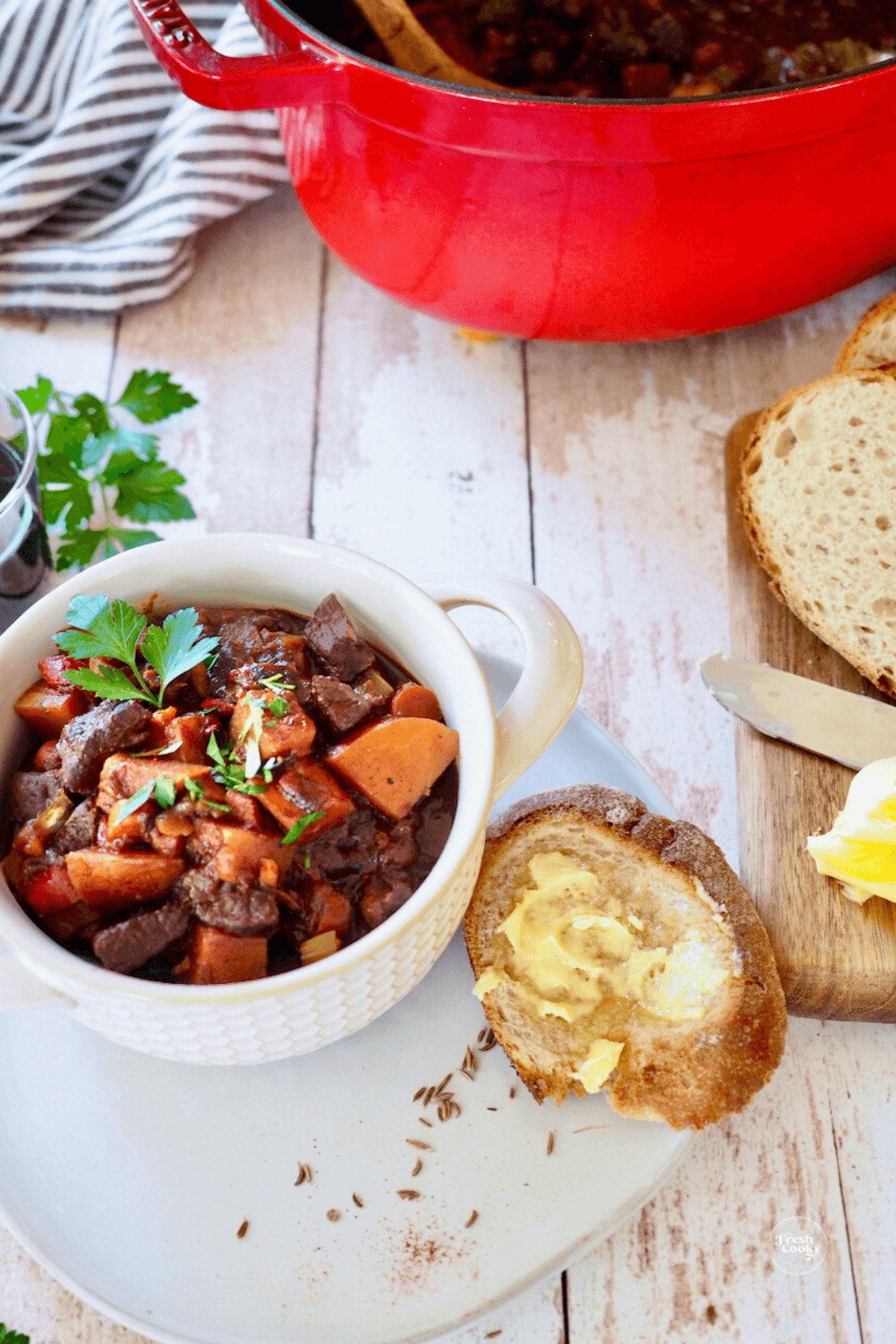 German goulash soup in bowl with rye bread and butter.