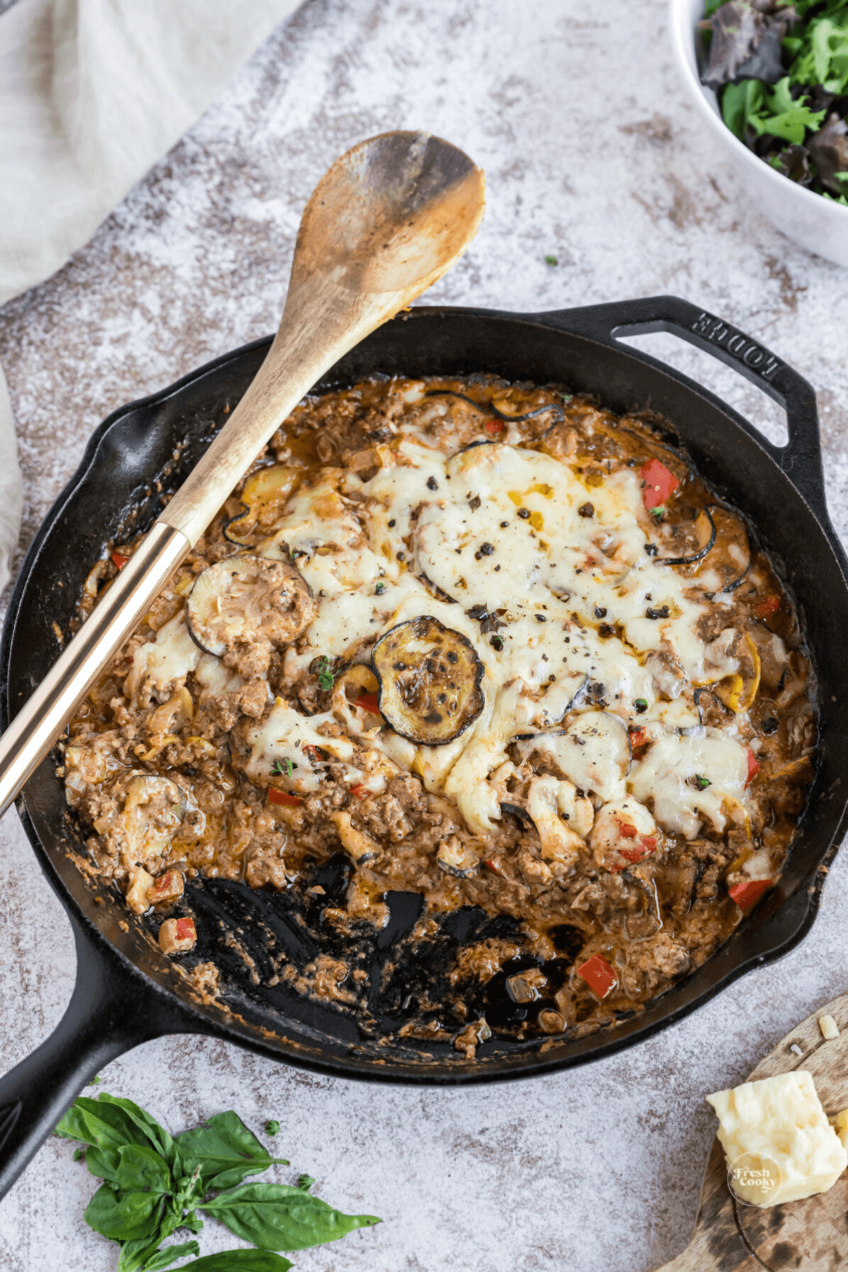 Cast iron skillet with zucchini ground beef casserole, serving removed.