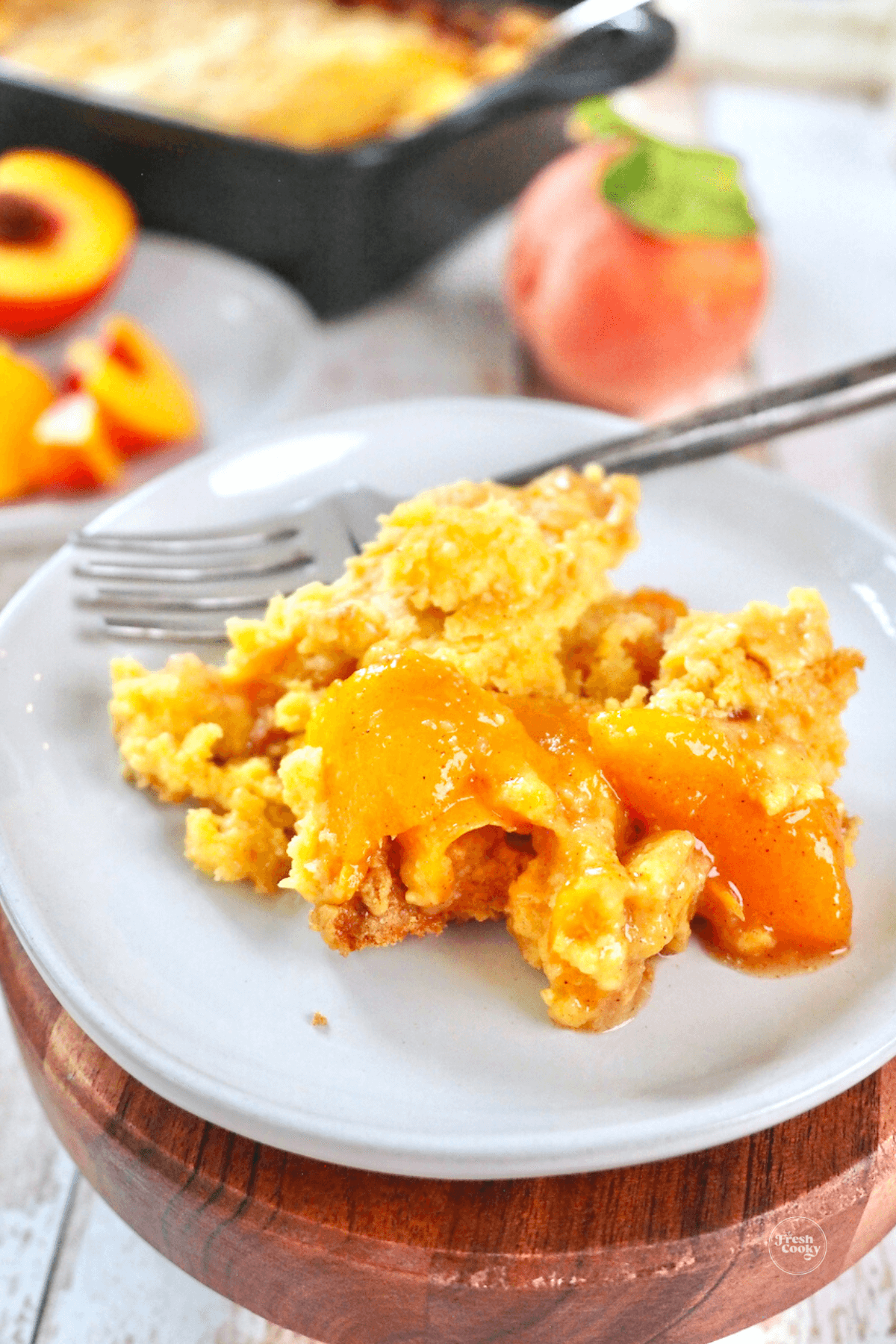 Fresh peach cobbler with cake mix streusel topping on plate with fork.