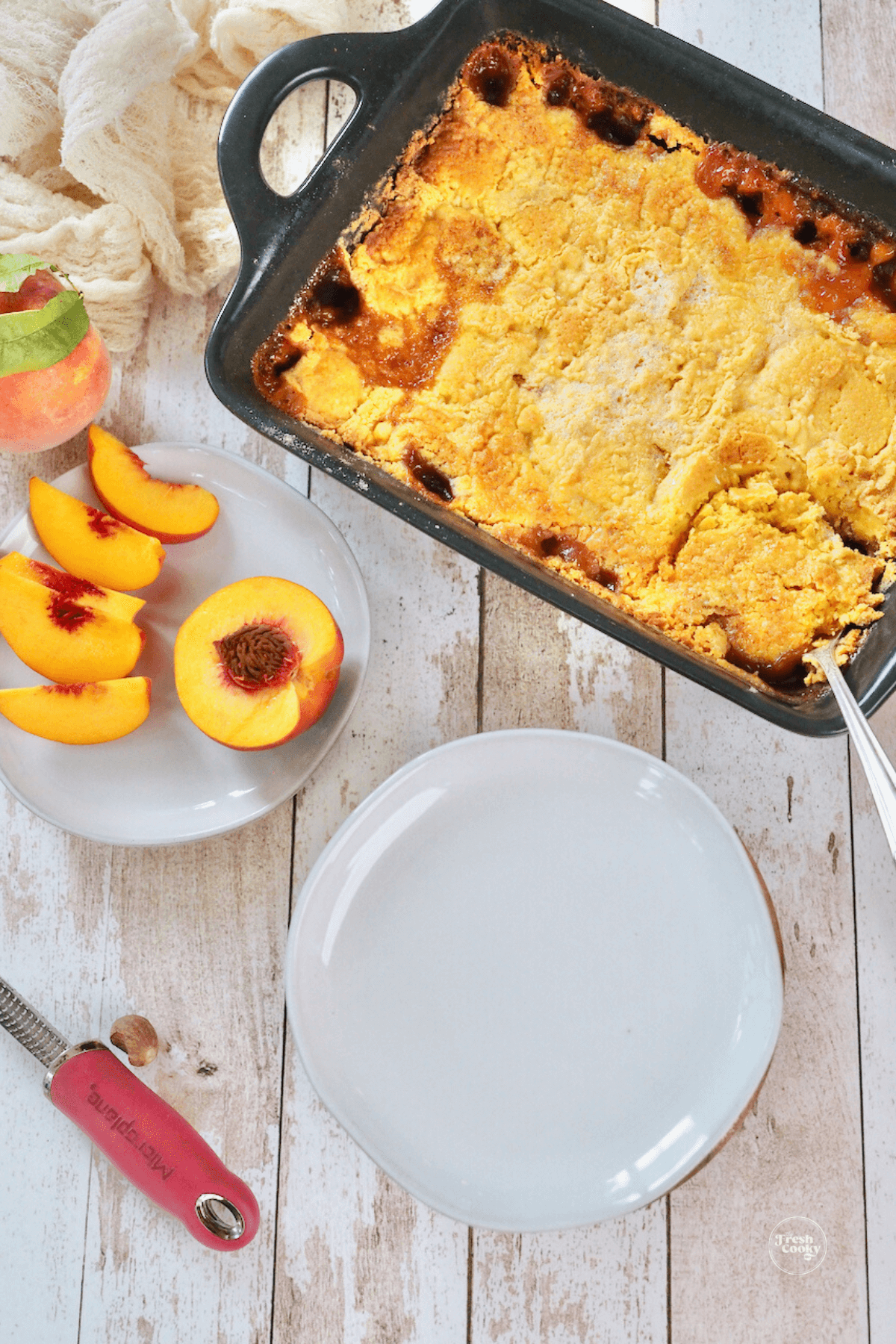 Peach cobbler with cake mix baked in pan, ready to serve.
