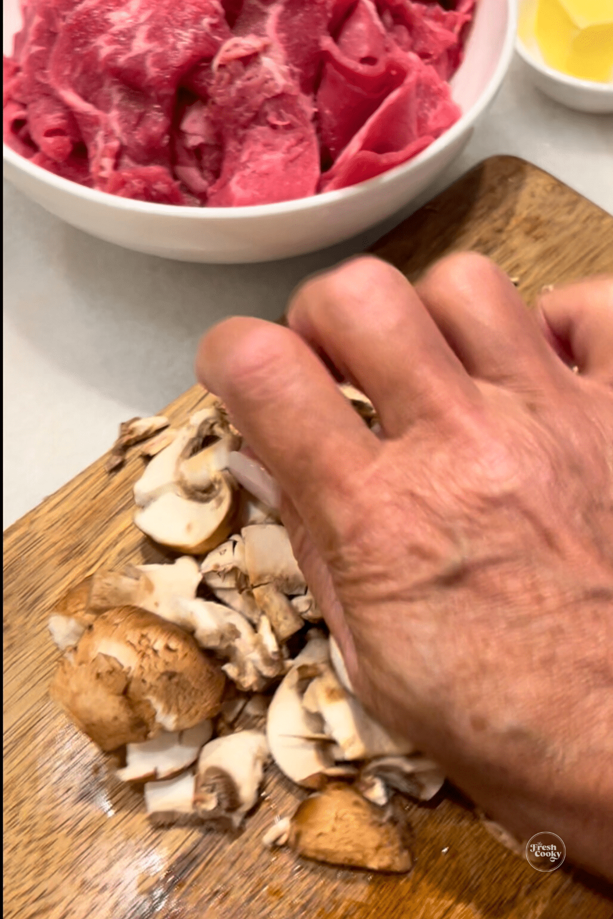 Smashing mushrooms on cutting board.