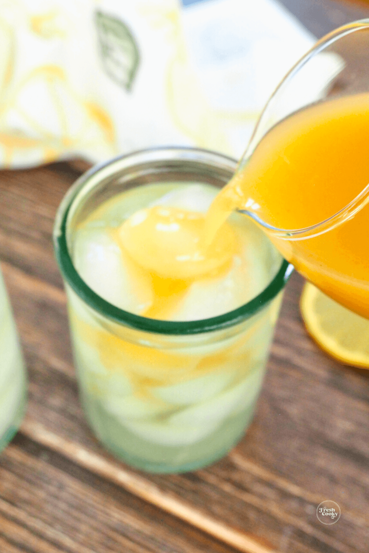 Pouring peach nectar into the top of the iced green tea.