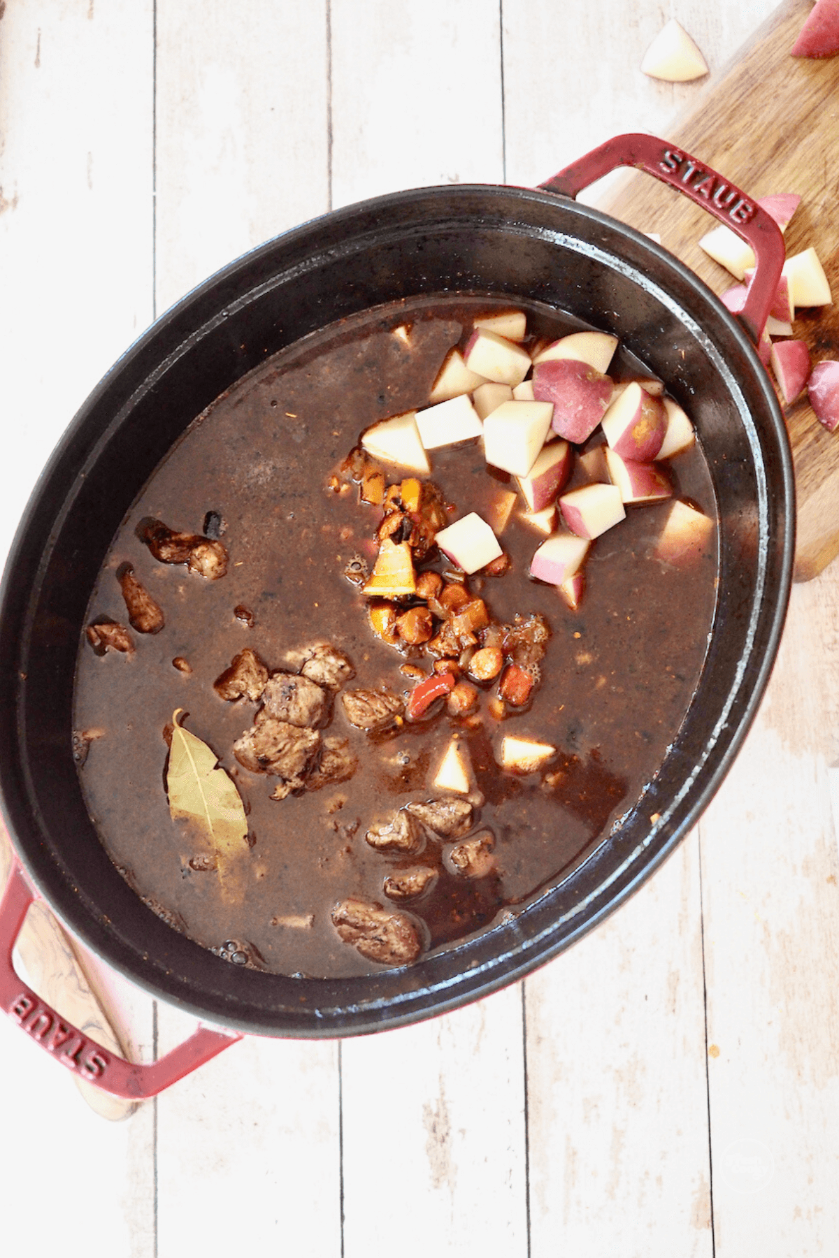 Soup added with veggies, beef, potatoes, bay leaves in beef broth.