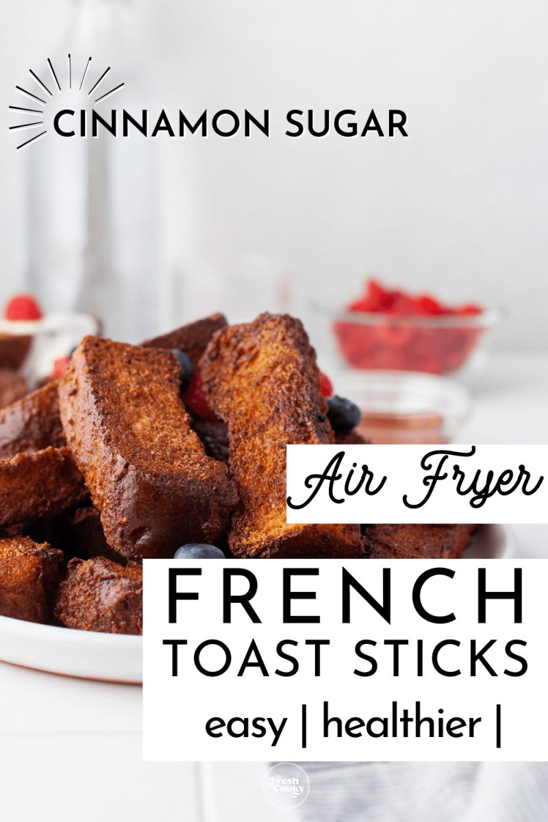 Cinnamon sugar french toast sticks on a plate with berries in background to pin.