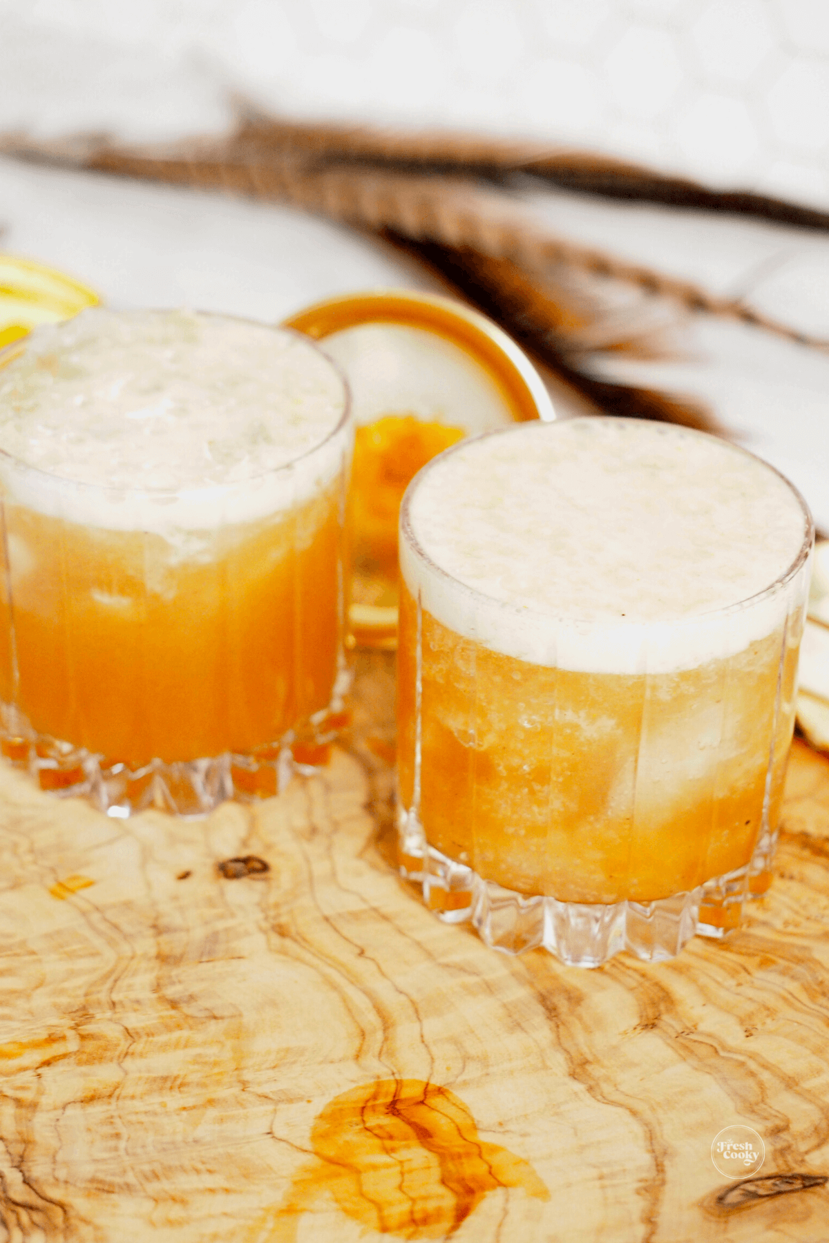 Bubbling glasses filled with apple cider cocktail and topped with ginger beer.