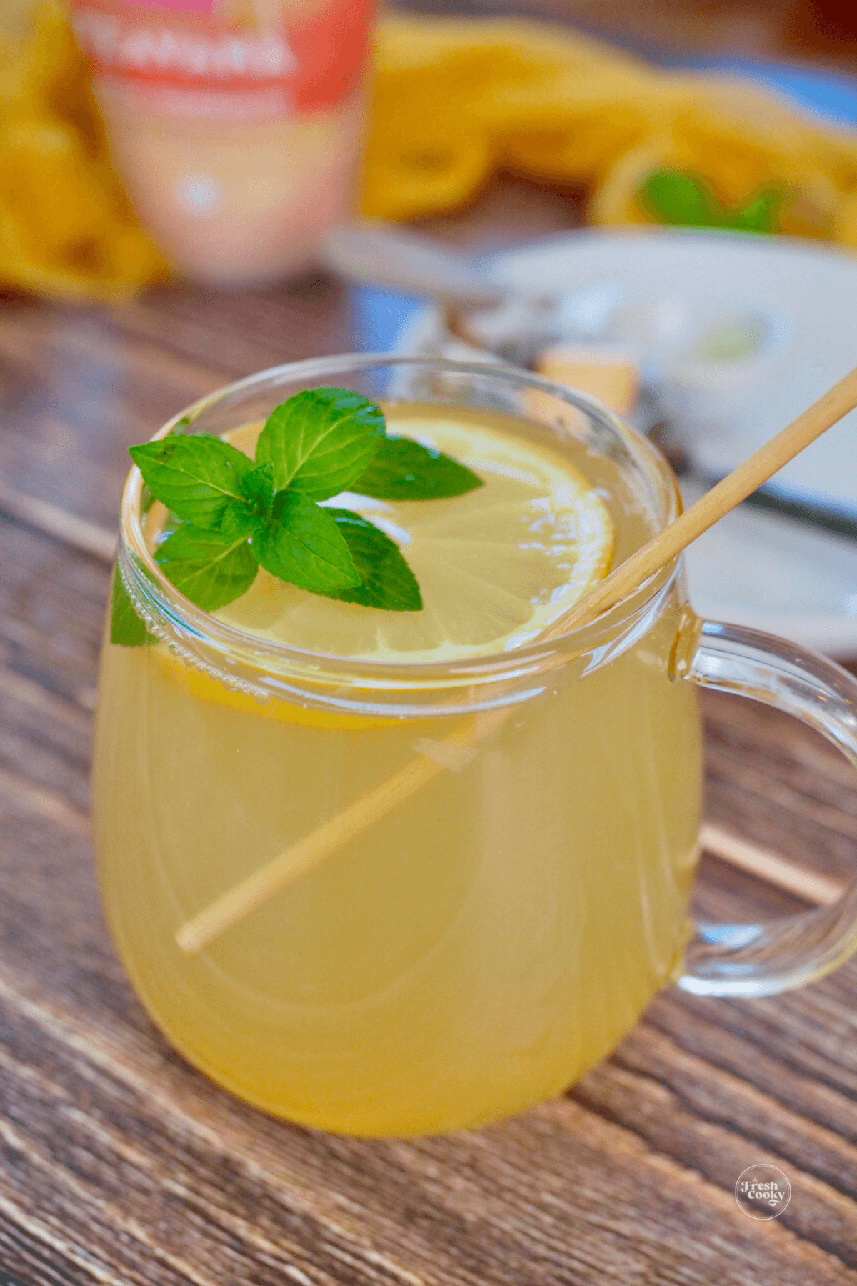 Teavana sore throat soother tea in a glass mug with lemon wheel, fresh mint and a stir stick.